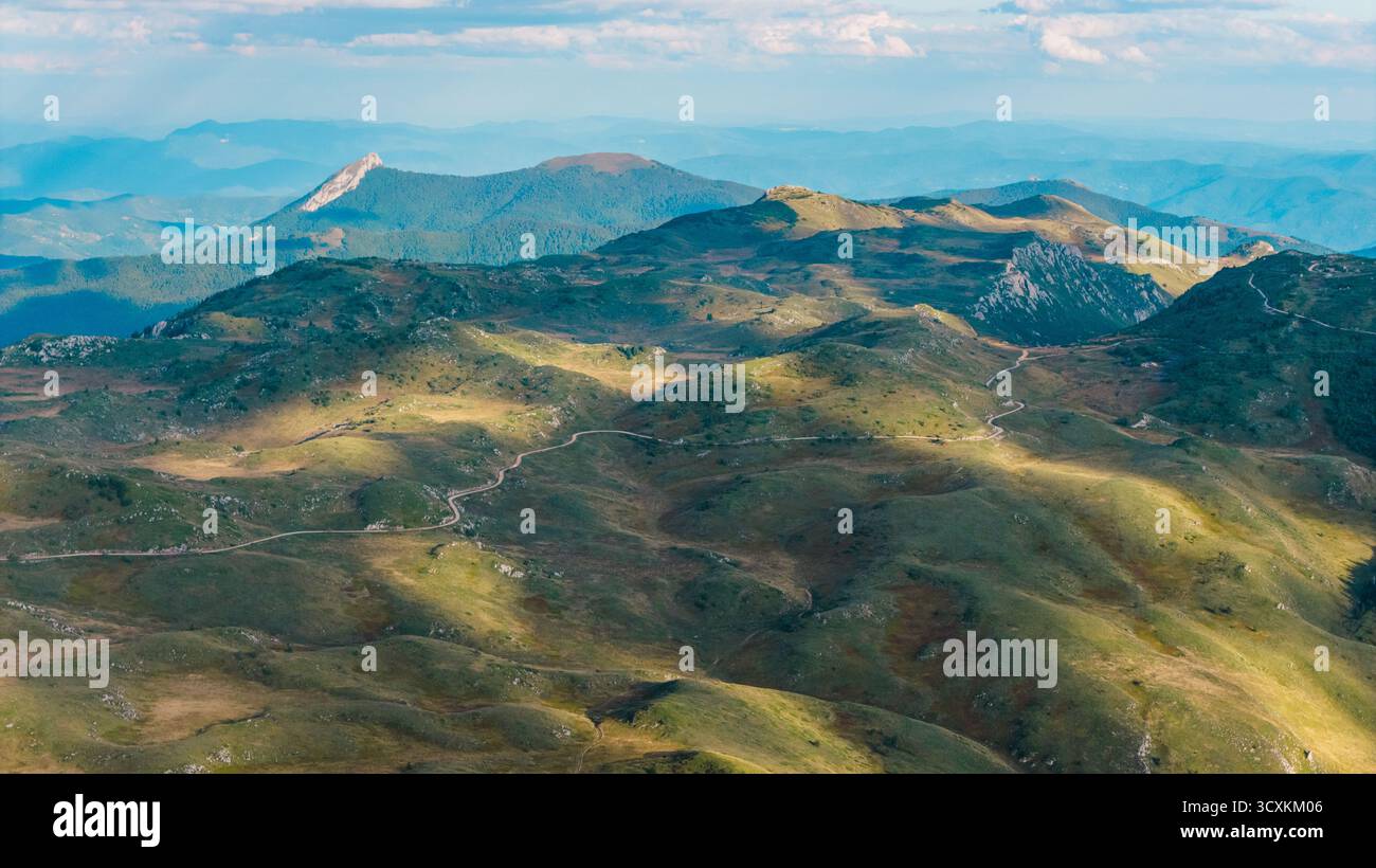 Vista aerea dell'altopiano montano con strada a serpentina e luce soffusa del pomeriggio Foto Stock