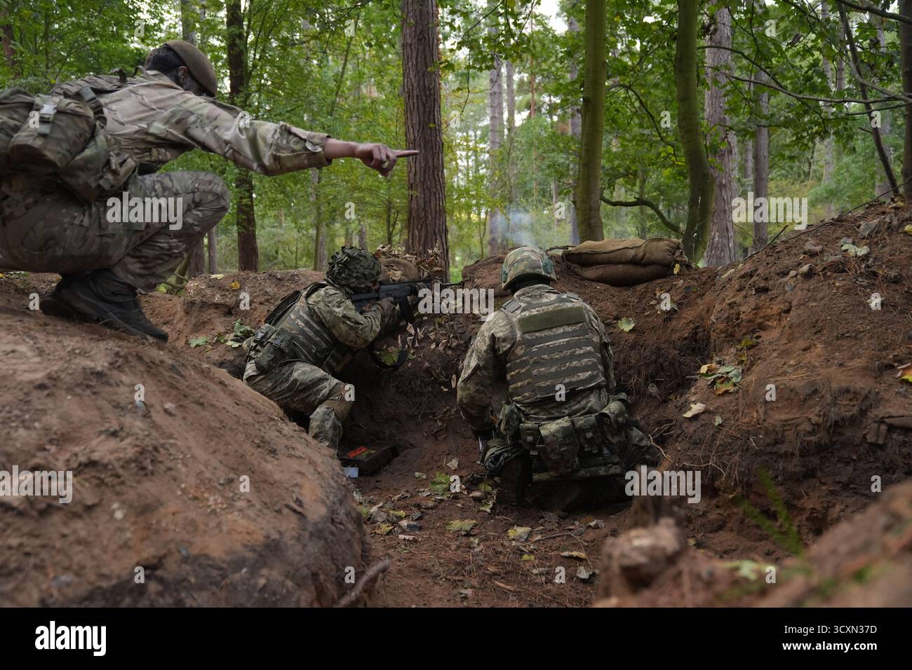 I soldati ucraini, che stanno ancora seguendo il loro corso di formazione per la leadership nell'ambito dell'operazione Interflex guidata dal Regno Unito, prendono parte all'addestramento di trincea condotto da membri delle guardie irlandesi in un campo di addestramento dell'esercito britannico nell'Inghilterra orientale. Data foto: Mercoledì 15 ottobre 2025. Foto Stock