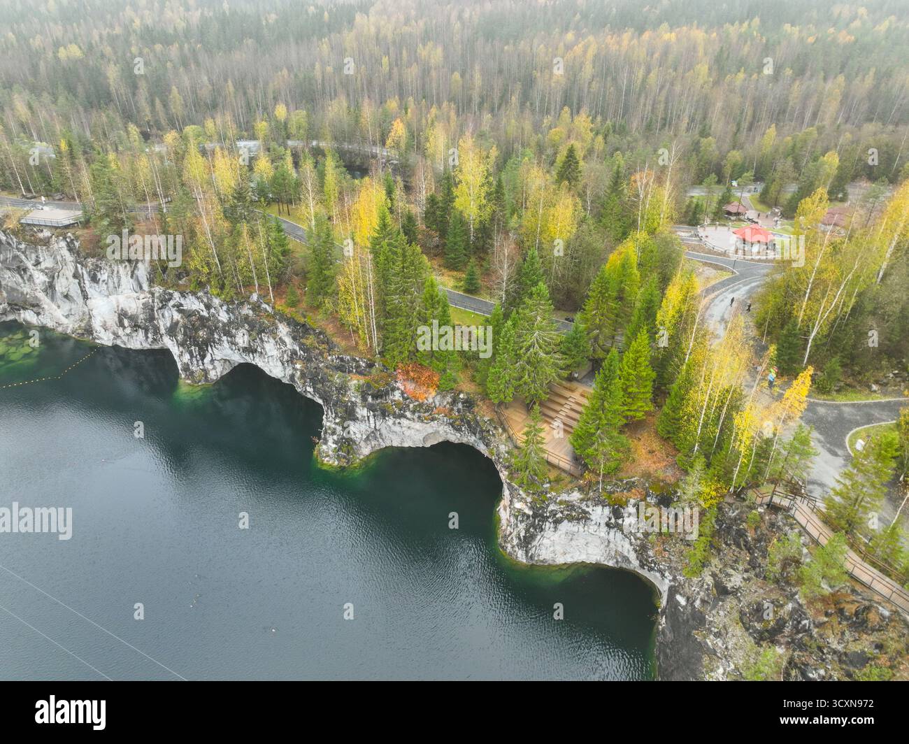 Immagine aerea ravvicinata delle scogliere di marmo bianco con grotte intagliate che scendono nelle acque blu profonde del canyon Foto Stock