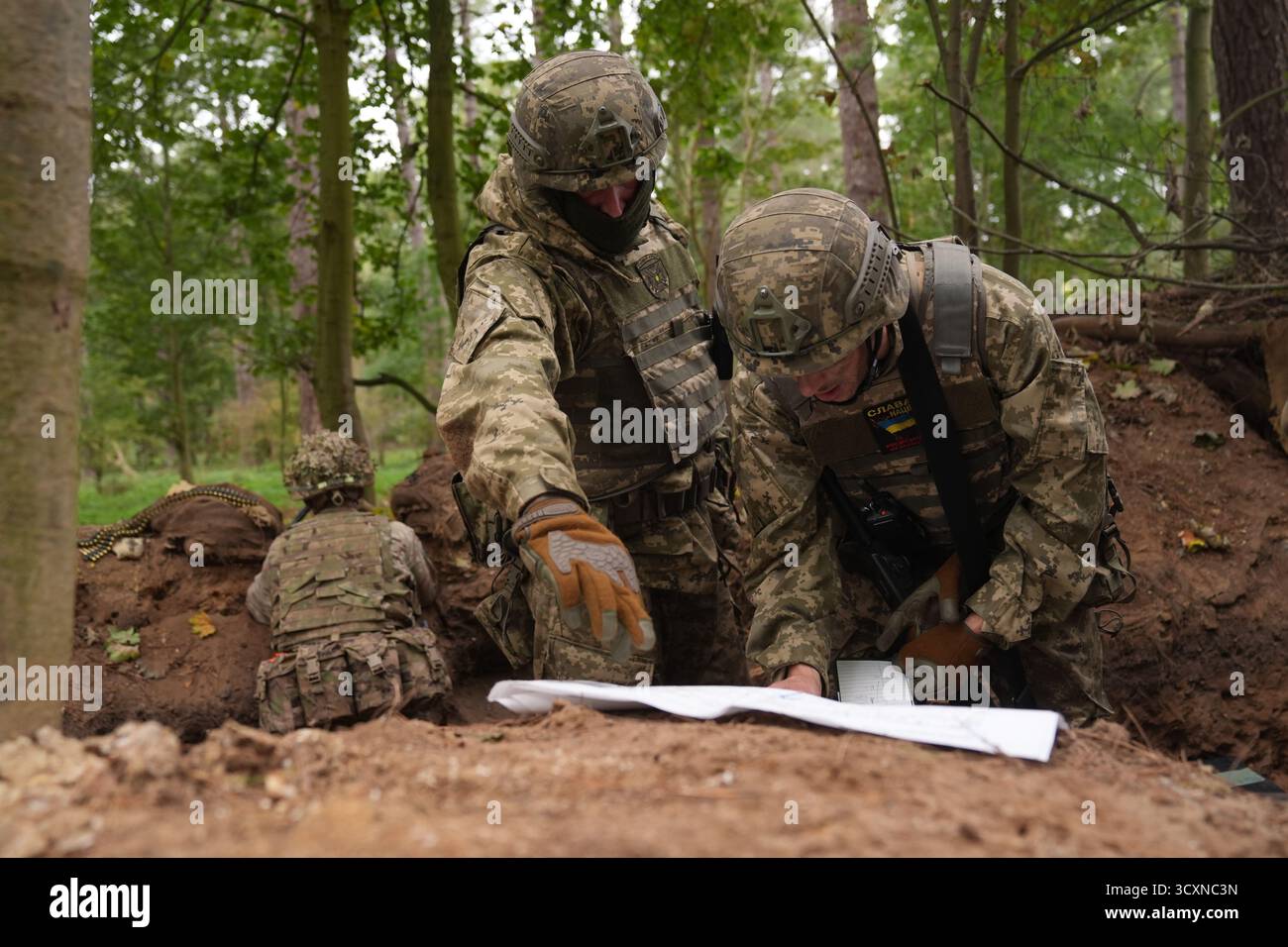 I soldati ucraini, che stanno ancora seguendo il loro corso di formazione per la leadership nell'ambito dell'operazione Interflex guidata dal Regno Unito, prendono parte all'addestramento di trincea condotto da membri delle guardie irlandesi in un campo di addestramento dell'esercito britannico nell'Inghilterra orientale. Data foto: Mercoledì 15 ottobre 2025. Foto Stock