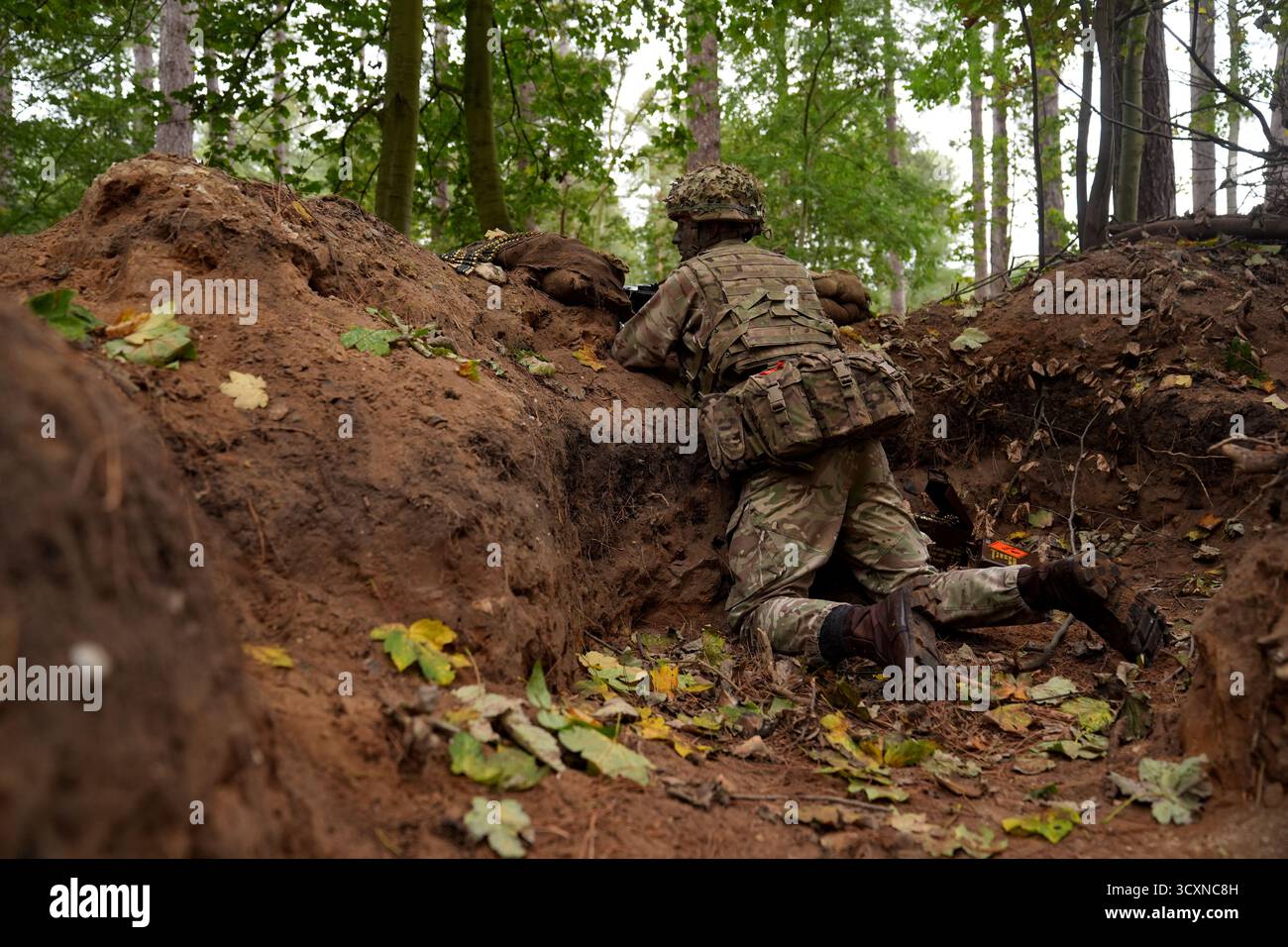 Un membro delle guardie irlandesi partecipa a un corso di formazione sulla leadership per i soldati ucraini, che stanno ancora seguendo il loro corso di formazione sulla leadership nell'ambito dell'operazione Interflex guidata dal Regno Unito, partecipa all'addestramento di trincea condotto da membri delle guardie irlandesi in un campo di addestramento dell'esercito britannico nell'Inghilterra orientale. Data foto: Mercoledì 15 ottobre 2025. Foto Stock