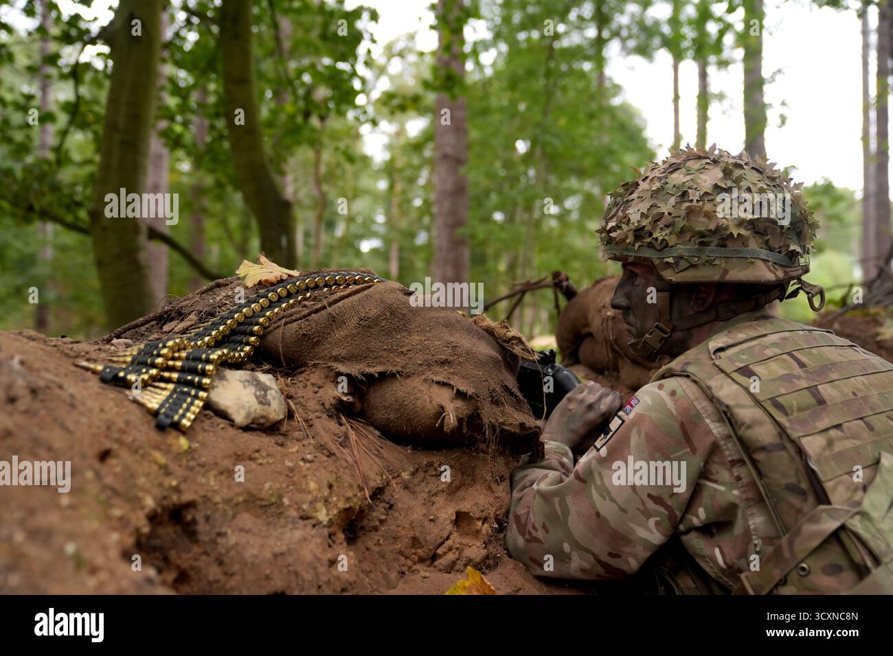 Un membro delle guardie irlandesi partecipa a un corso di formazione sulla leadership per i soldati ucraini, che stanno ancora seguendo il loro corso di formazione sulla leadership nell'ambito dell'operazione Interflex guidata dal Regno Unito, partecipa all'addestramento di trincea condotto da membri delle guardie irlandesi in un campo di addestramento dell'esercito britannico nell'Inghilterra orientale. Data foto: Mercoledì 15 ottobre 2025. Foto Stock