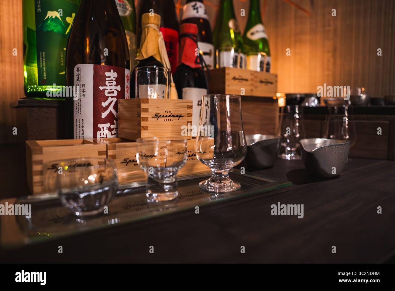 Banco bar giapponese dell'hotel con bottiglie di sake e set di degustazione Foto Stock