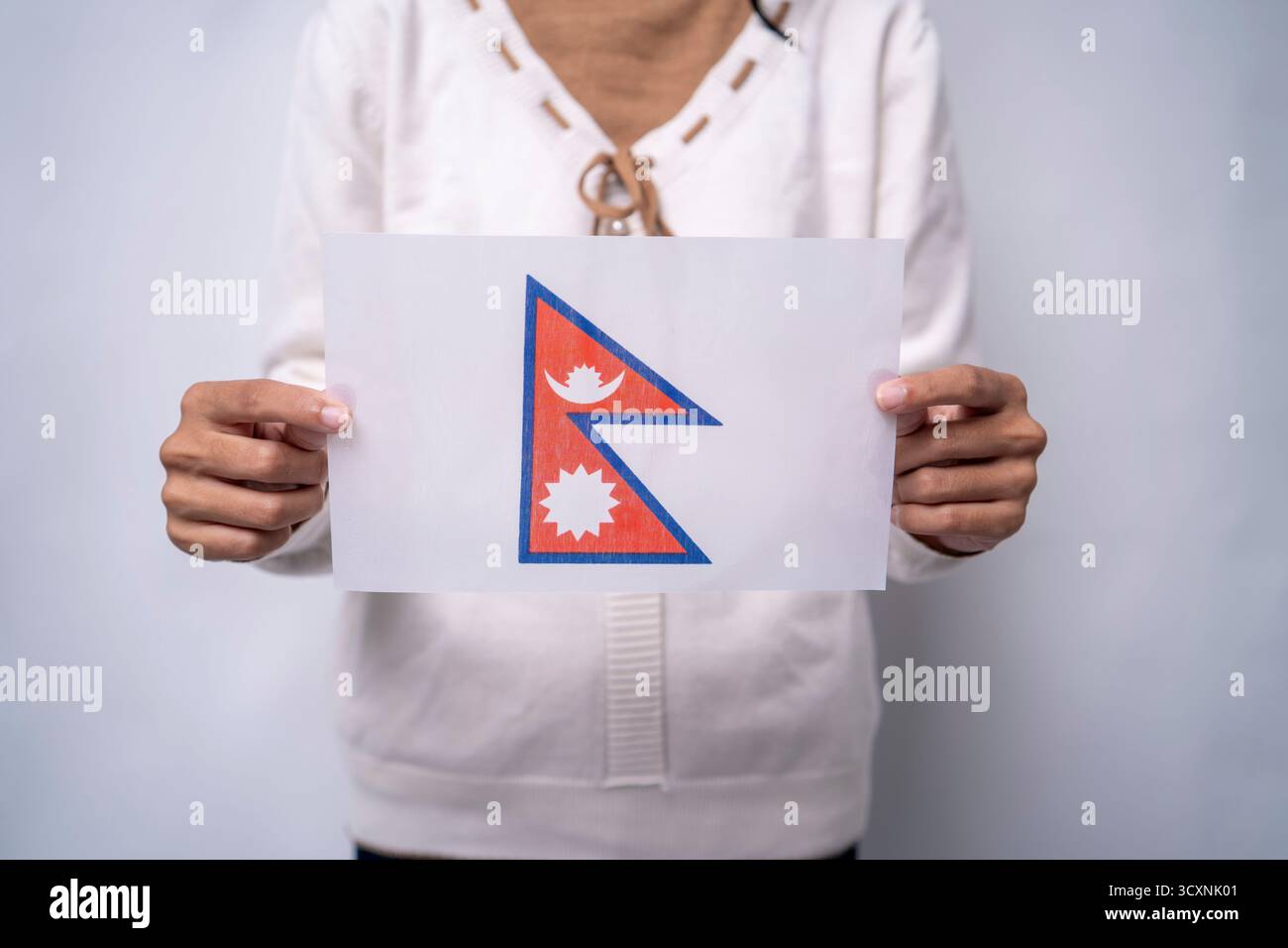 Persona che detiene la bandiera del Nepal Foto Stock