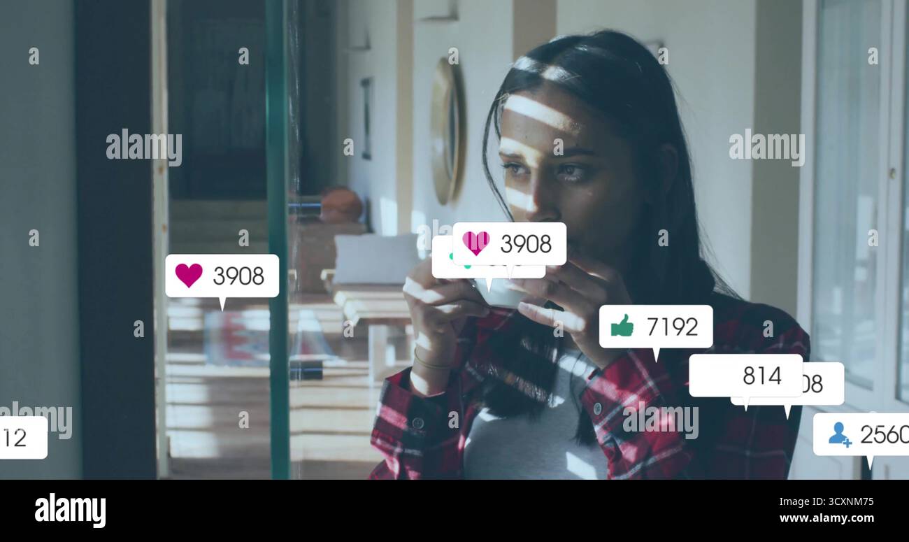 Donna in piedi accanto alle tapparelle in cucina, con tazza da caffè, libri, cappello di paglia, icone sociali, copia spazio Foto Stock