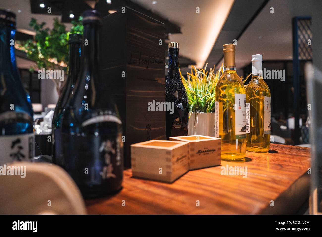 Bar di lusso in Giappone con bottiglie di sake, vino e tazze di masu Foto Stock