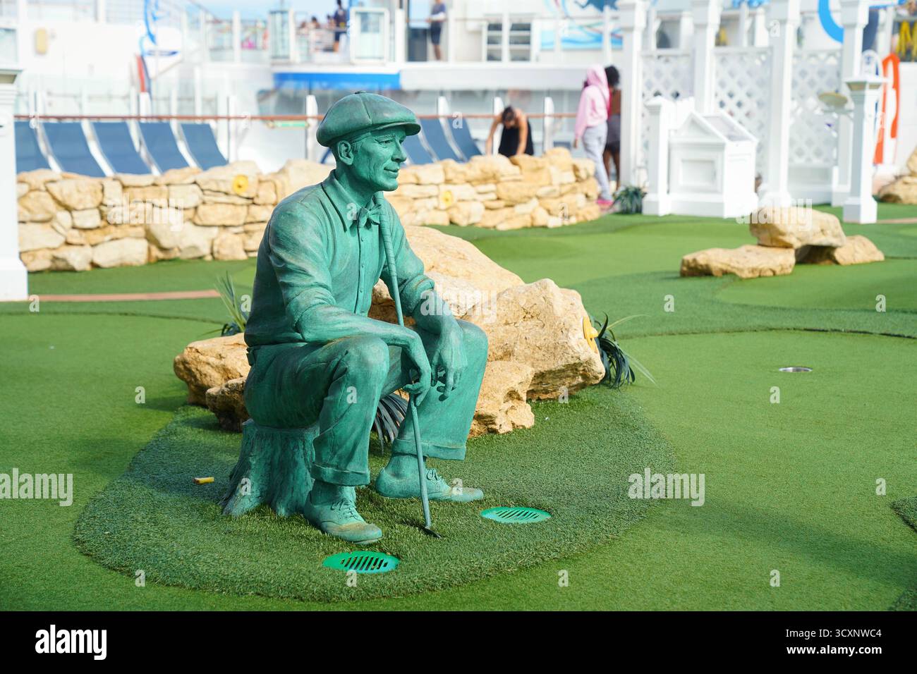Scultura verde bronzo di un golfista seduto esposta sul campo da minigolf a bordo dell'Allure of the Seas dei Caraibi reali Foto Stock