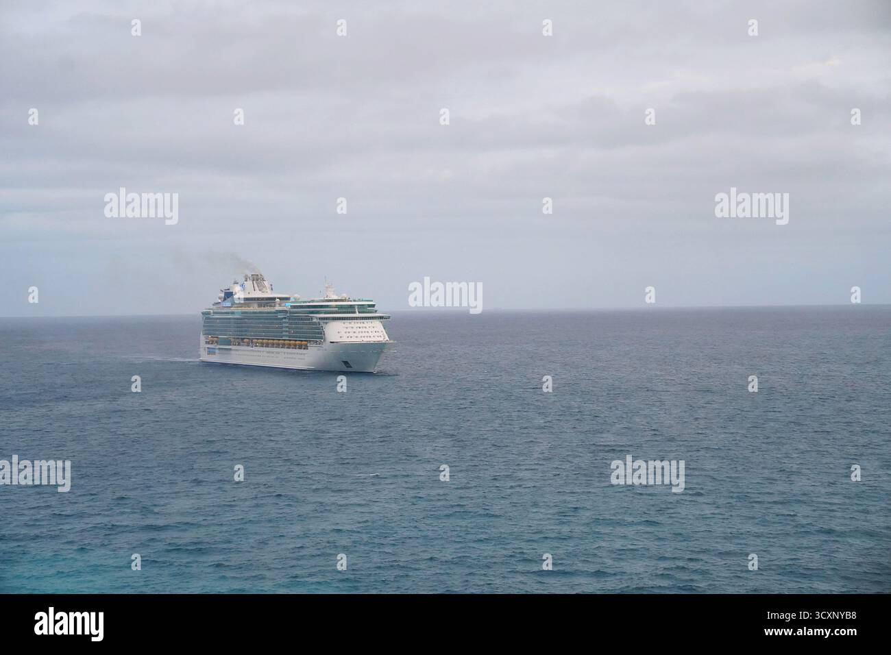 La Liberty of the Seas naviga attraverso le acque aperte sotto cieli nuvolosi, con il suo massiccio profilo a più ponti che ne sottolinea le dimensioni Foto Stock