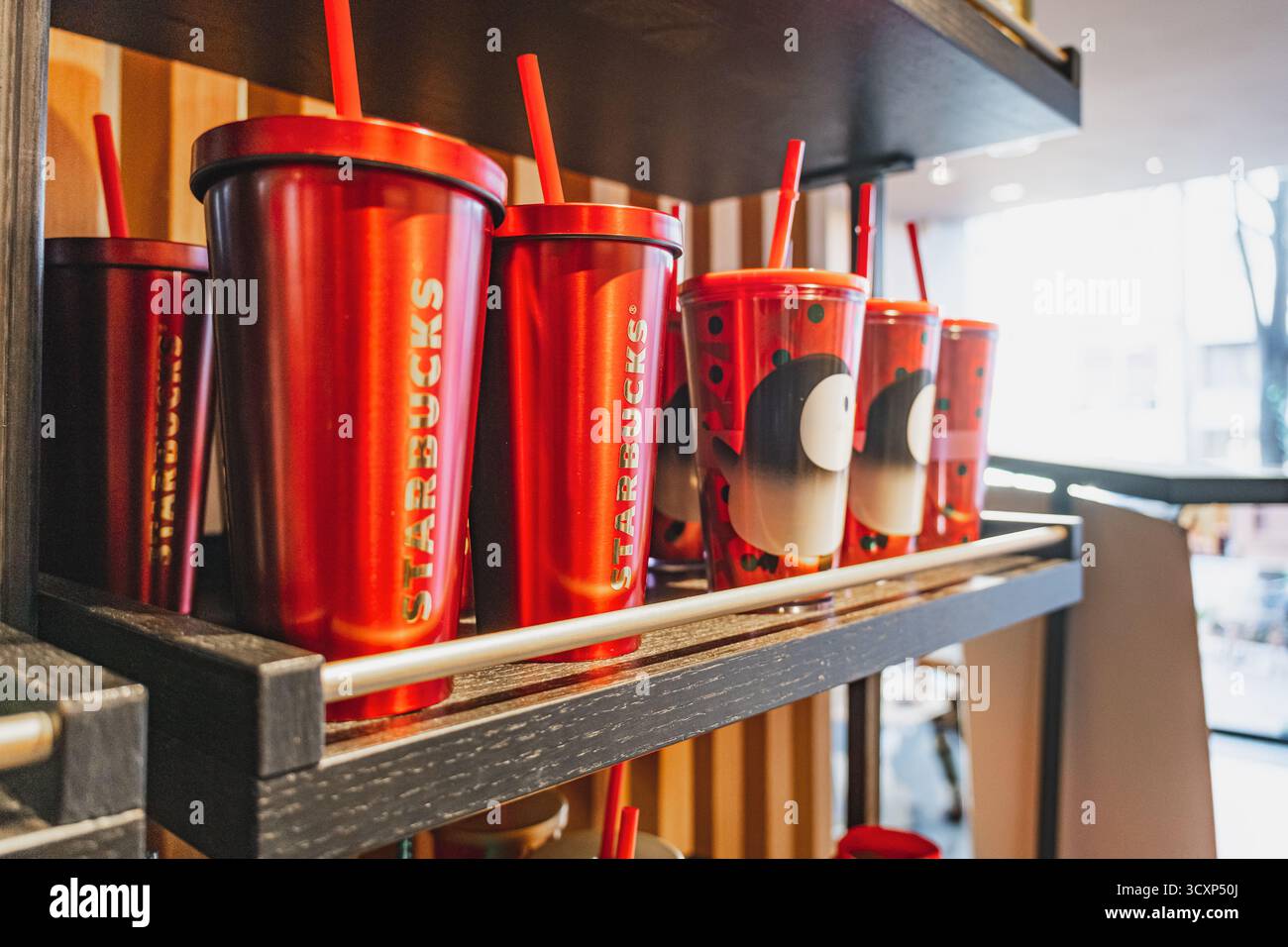 Durante le festività natalizie, tazze riutilizzabili con cannucce esposte all'interno del bar Starbucks Foto Stock
