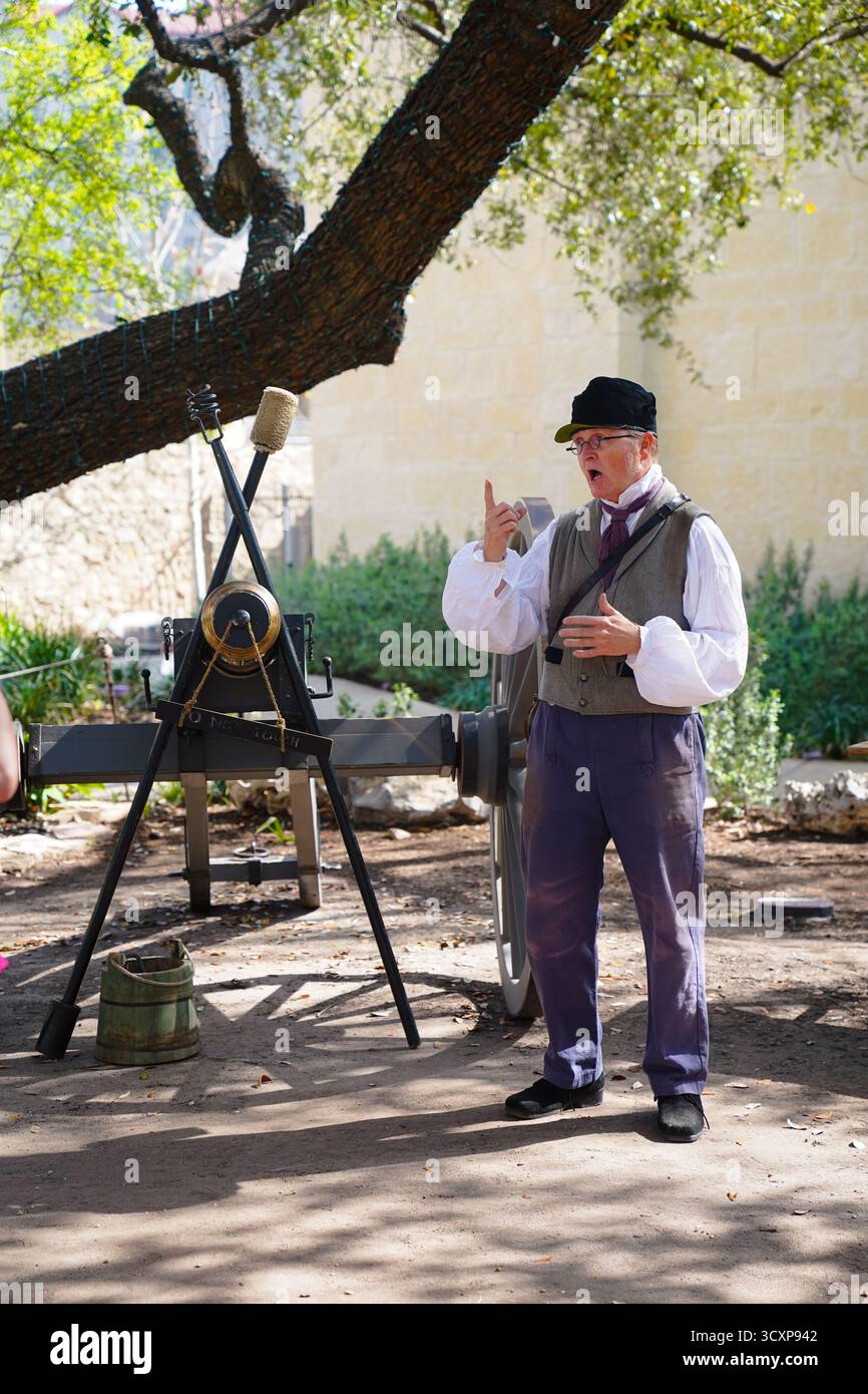 Il rievocatore storico in abiti del XIX secolo offre una dimostrazione di cannoni dal vivo durante un evento di storia vivente presso la missione di Alamo Foto Stock