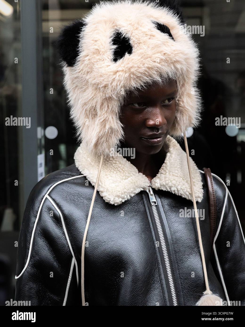 Un ospite alla moda che indossa una giacca in pelle e un cappello Panda di grande impatto partecipa alla mostra Primavera/Estate 2026 di Issey Miyake durante la settimana della moda di Parigi. Foto Stock