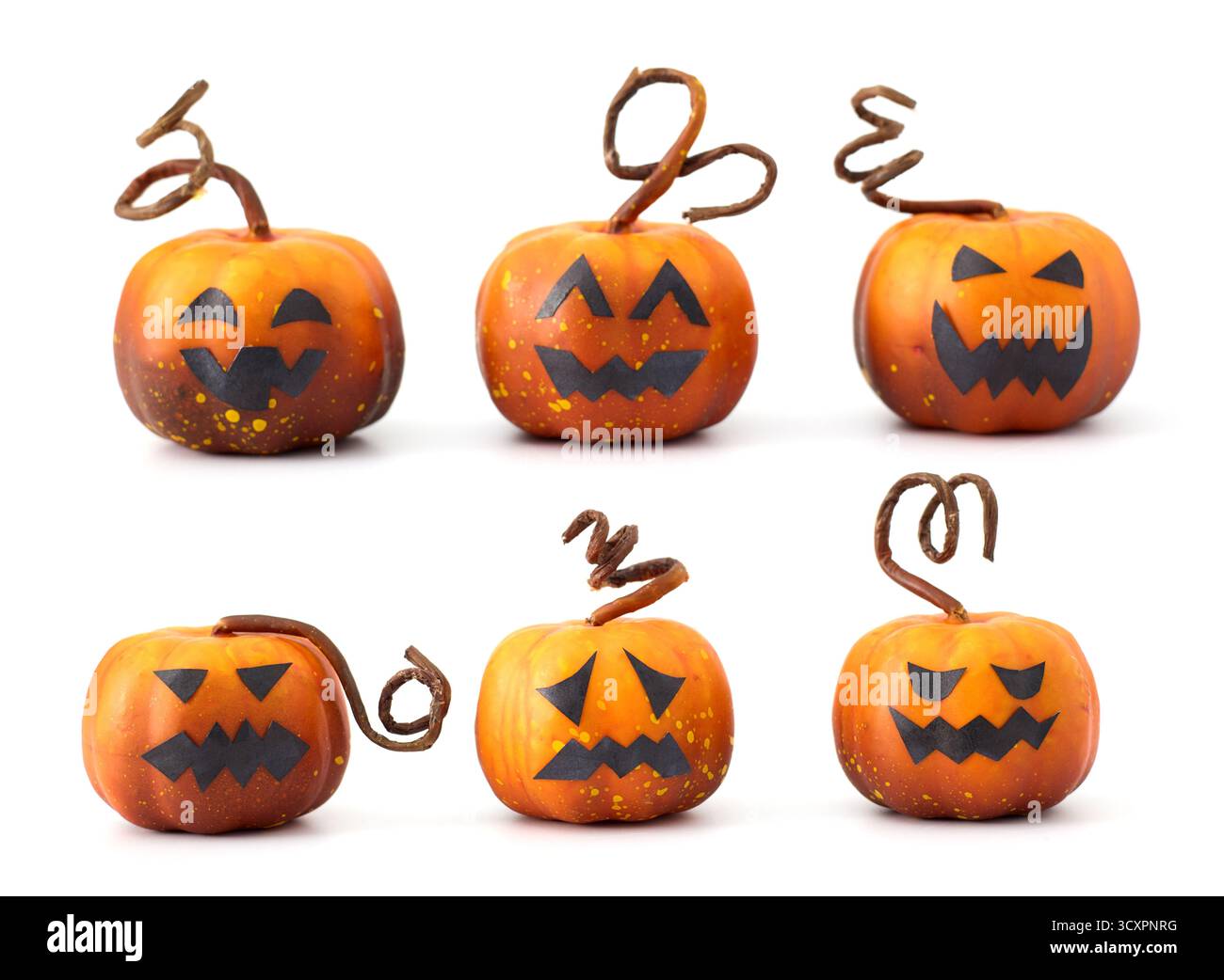 Simpatiche zucche di Halloween con facce di Jack-o'-lantern disposte in un gruppo giocoso su sfondo bianco Foto Stock