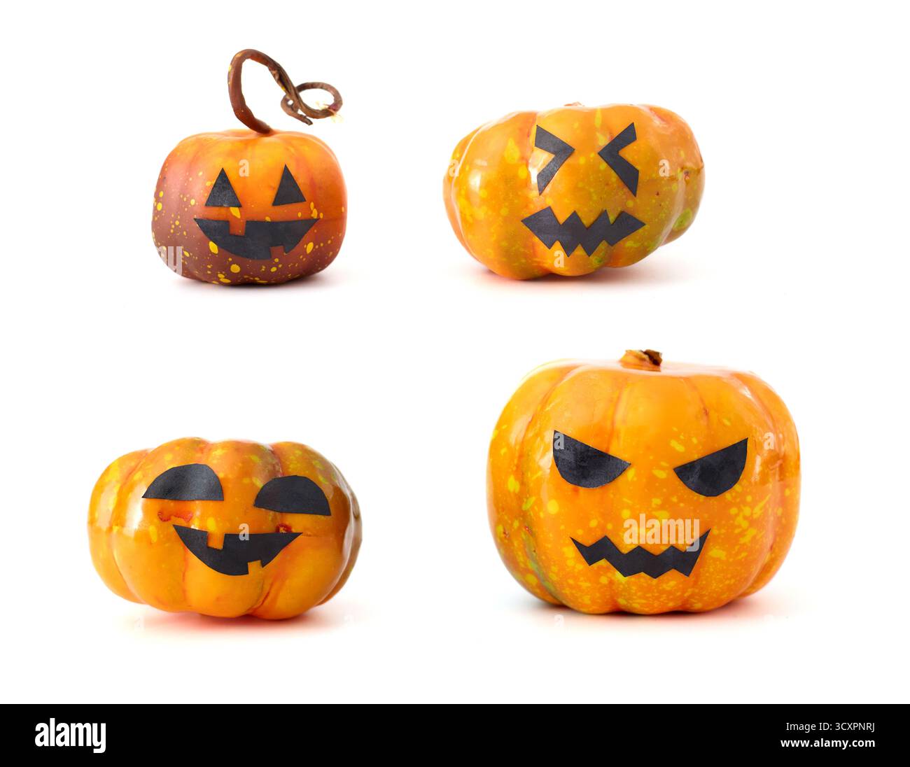 Simpatiche zucche di Halloween con facce di Jack-o'-lantern disposte in un gruppo giocoso su sfondo bianco Foto Stock