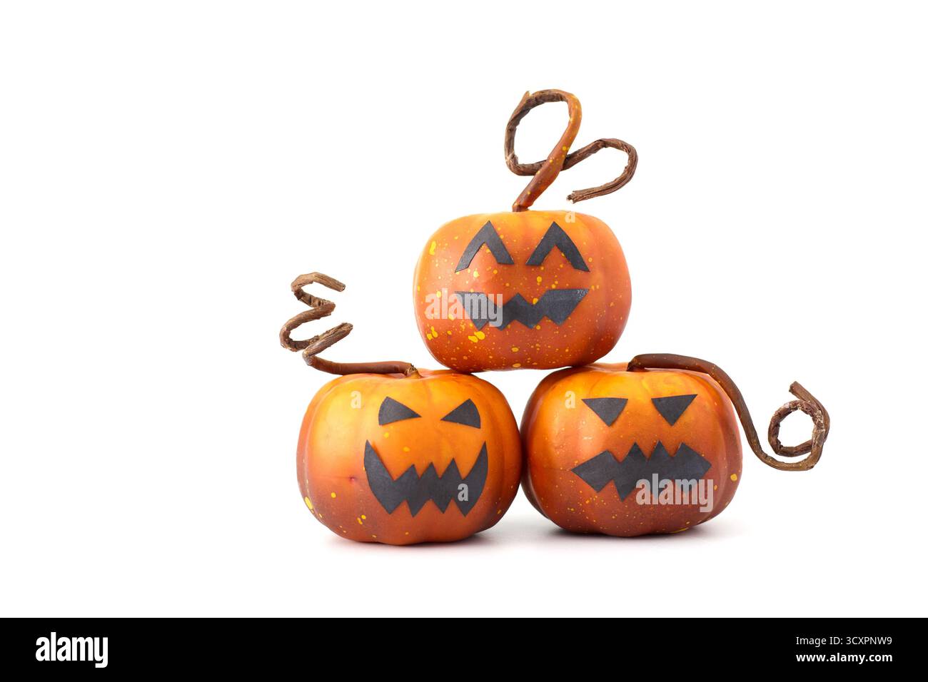Simpatiche zucche di Halloween con facce di Jack-o'-lantern disposte in un gruppo giocoso su sfondo bianco Foto Stock