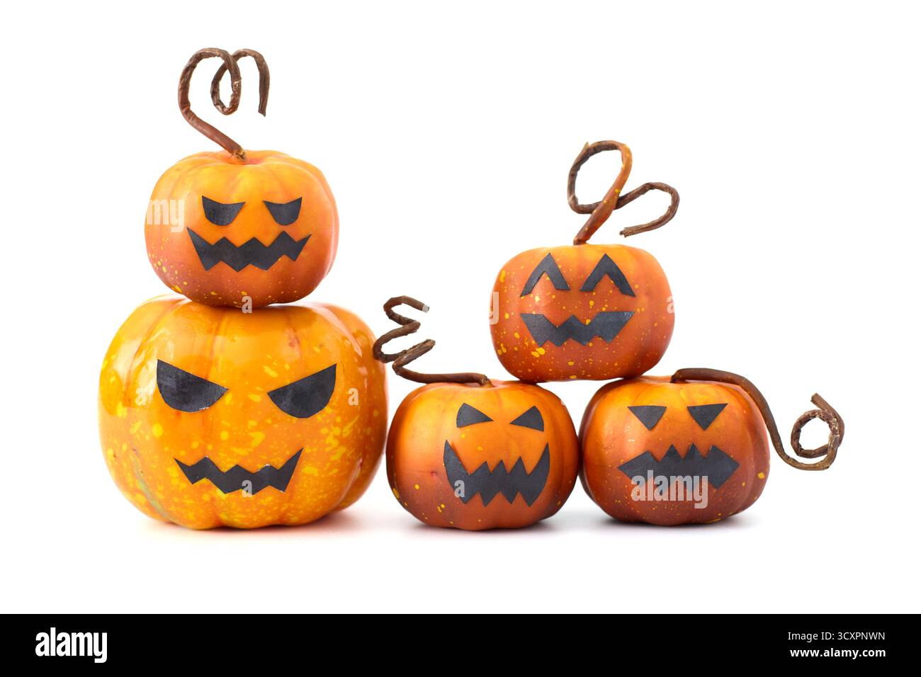 Simpatiche zucche di Halloween con facce di Jack-o'-lantern disposte in un gruppo giocoso su sfondo bianco Foto Stock
