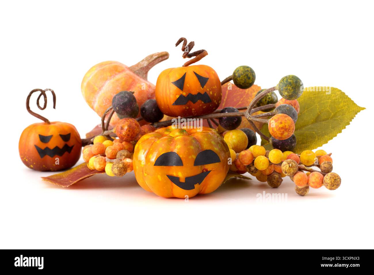 Natura morta di Halloween con piccole zucche jack-o'-lanterne, pinne, foglie autunnali e sfondo bianco Foto Stock