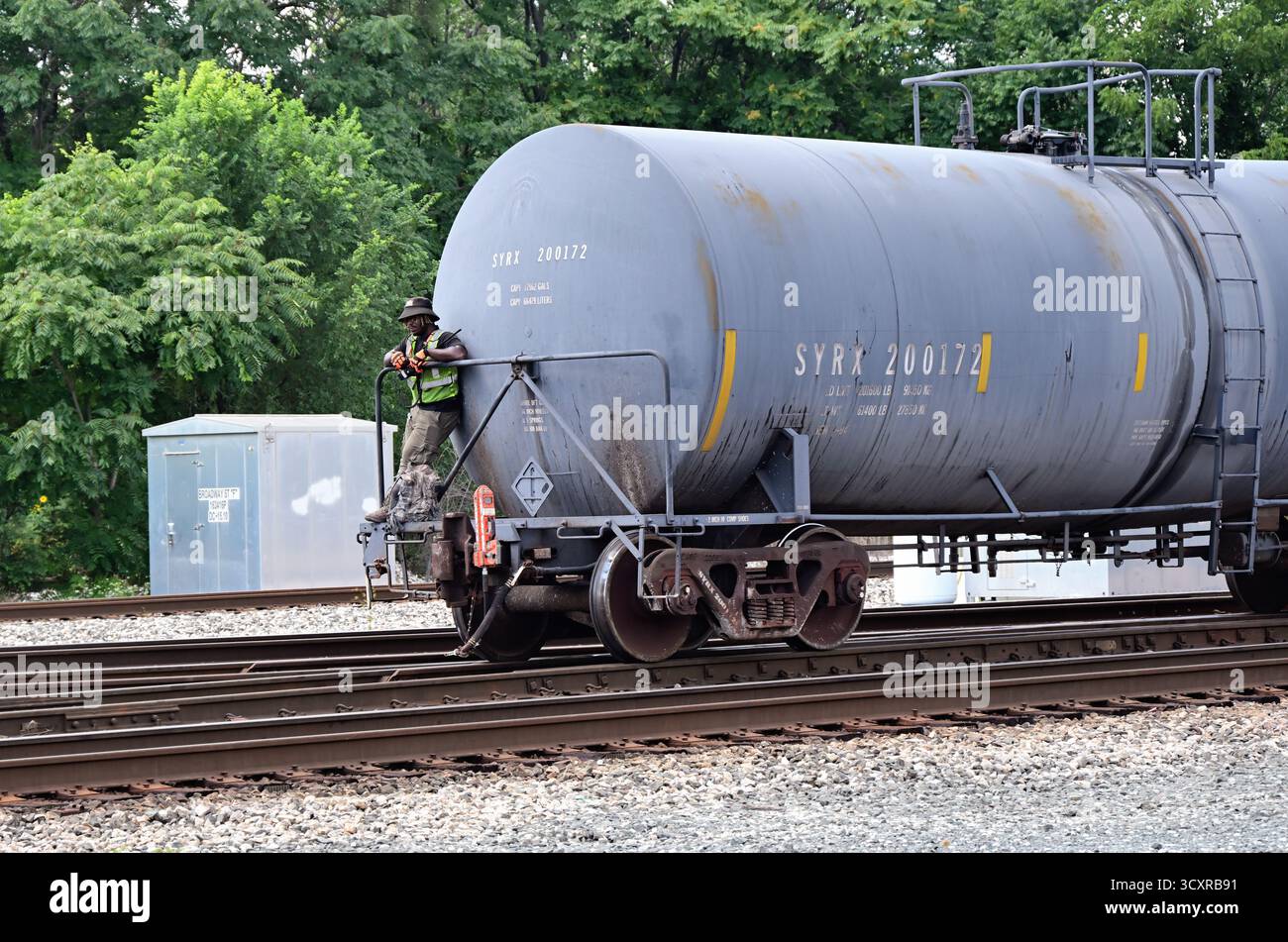 Blue Island, Illinois, Stati Uniti. Un centralino tiene sulla ringhiera di un carro armato sul retro di un treno libero. Foto Stock