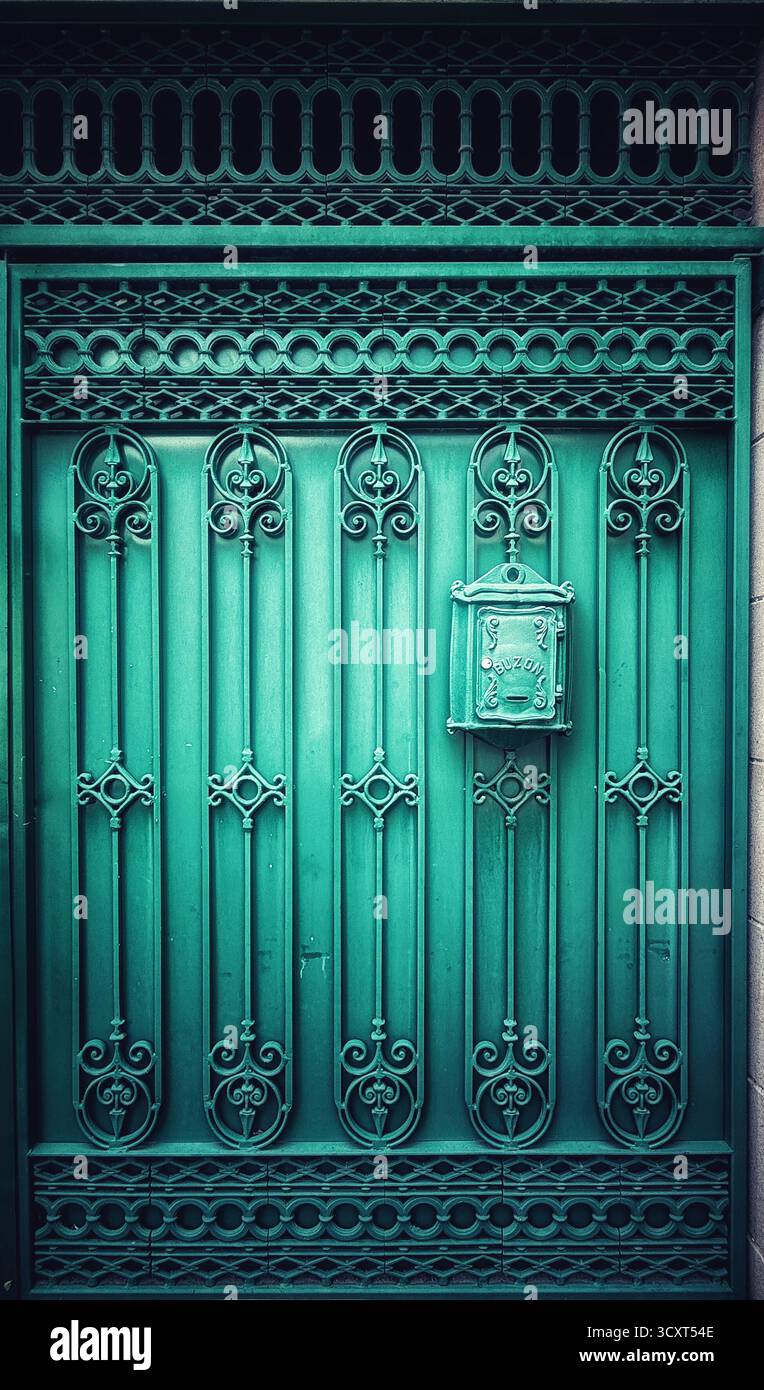Cancello in metallo turchese decorato con motivi decorativi intricati e una cassetta postale vintage in un ambiente urbano - Immagine stock catturata con smartphone