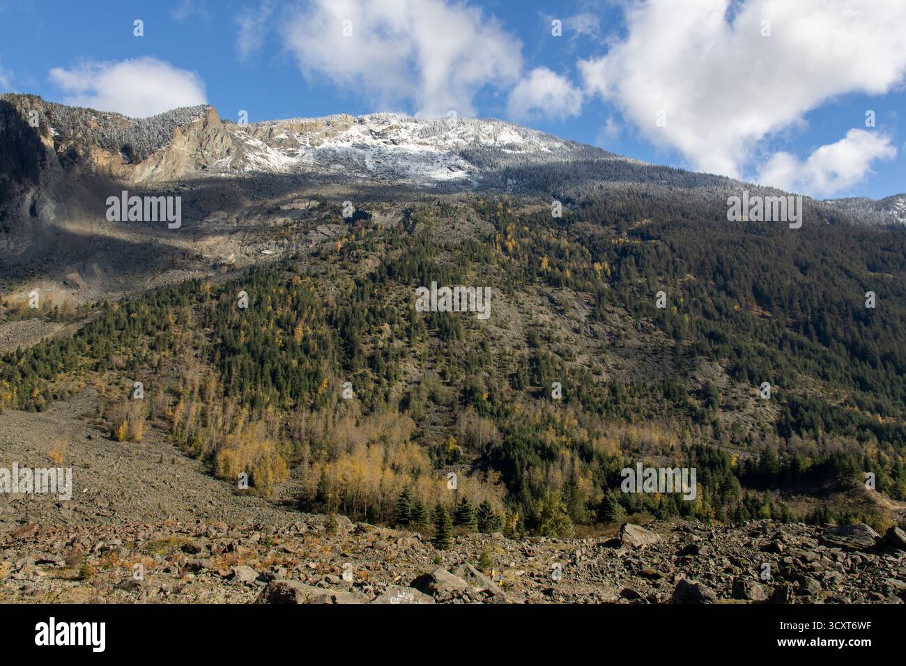 Paesaggio montano autunnale con un pendio roccioso, foresta mista e vette innevate presso Hope Slide Site, British Columbia, Canada Foto Stock