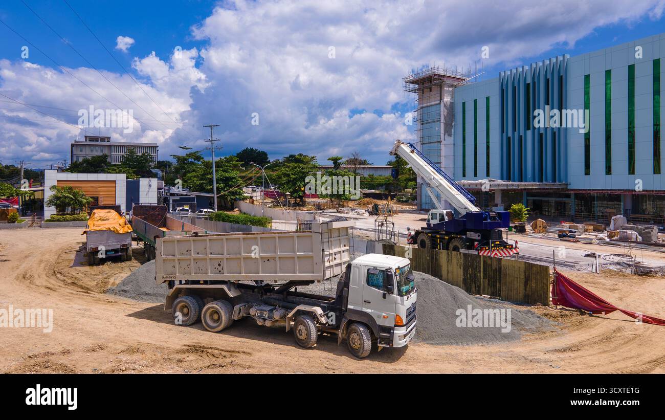 Vista aerea di un moderno centro commerciale in costruzione con pannelli di rivestimento metallici e attrezzature pesanti visibili Foto Stock
