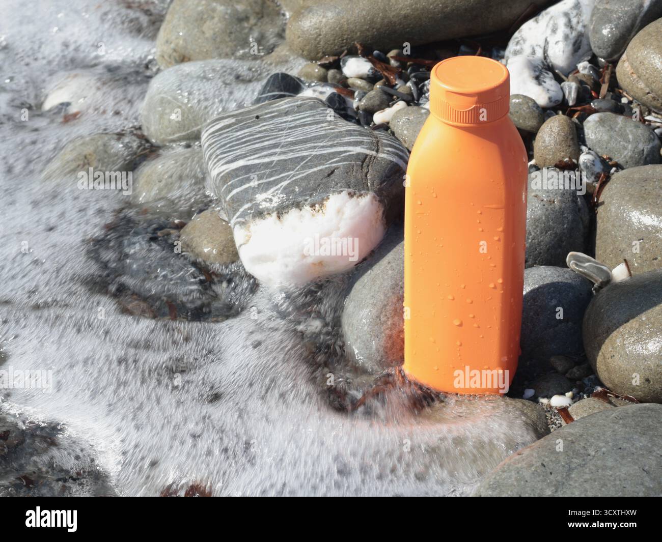 Vaso di bellezza rosso in plastica sullo sfondo di elementi naturali. Cosmetici e cura del viso e dei capelli. Modello per la progettazione. Prodotti ecocompatibili Foto Stock
