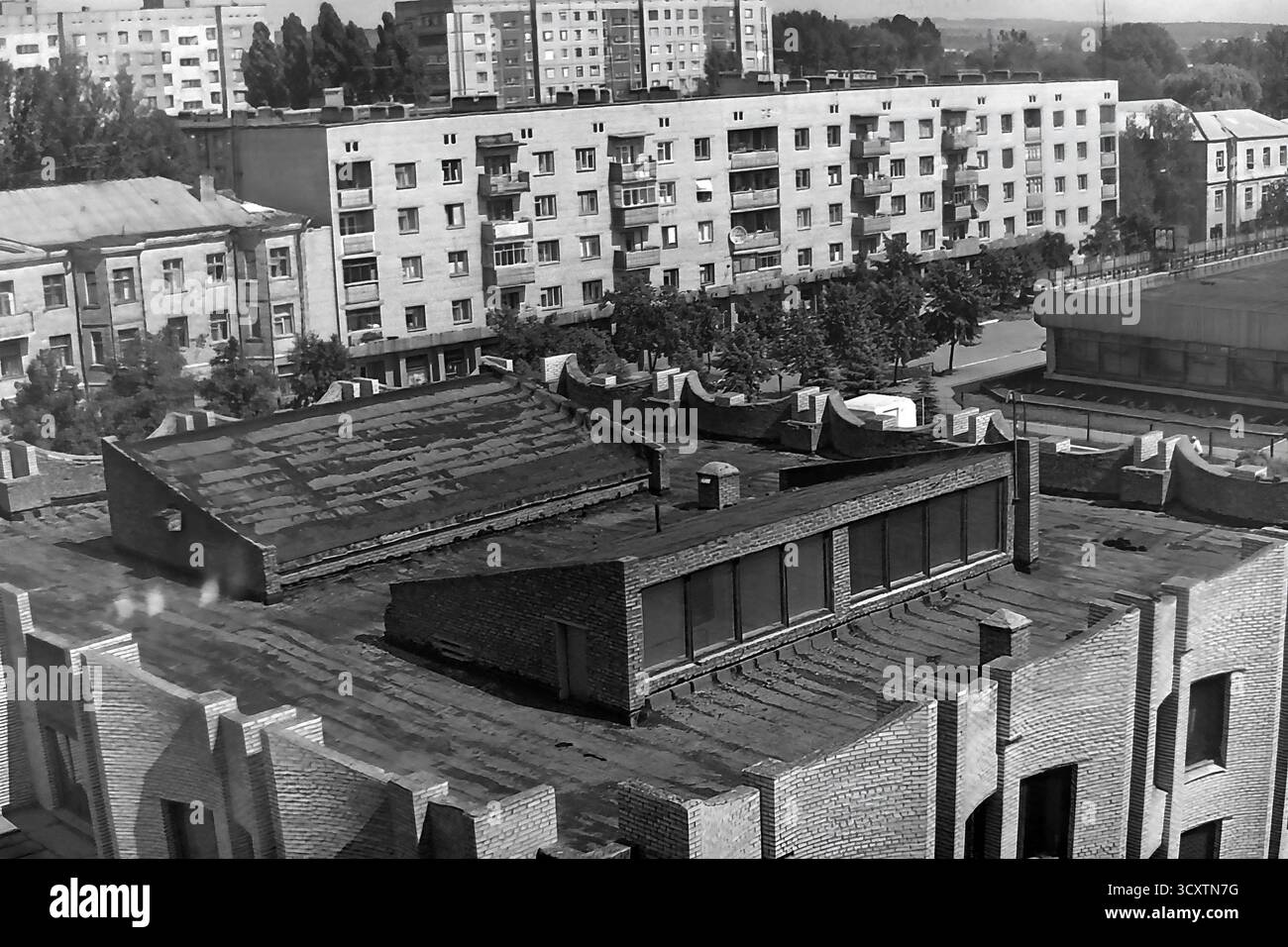 Una suggestiva foto d'archivio ad alto angolo degli anni '1980 cattura la texture urbana di Sloviansk, RSS Ucraina. La vista si affaccia sul caratteristico tetto modernista della Biblioteca centrale della città, situata in Piazza della Rivoluzione d'ottobre (ora Piazza Soborna). Oltre alla biblioteca, i tipici edifici residenziali di epoca sovietica sono lungo via Lenina (ora via Universytetska). Questa immagine mette in evidenza i contrasti architettonici dell'epoca ed è una preziosa testimonianza dell'ambiente urbano quotidiano di un tranquillo Donbas prima della guerra Foto Stock