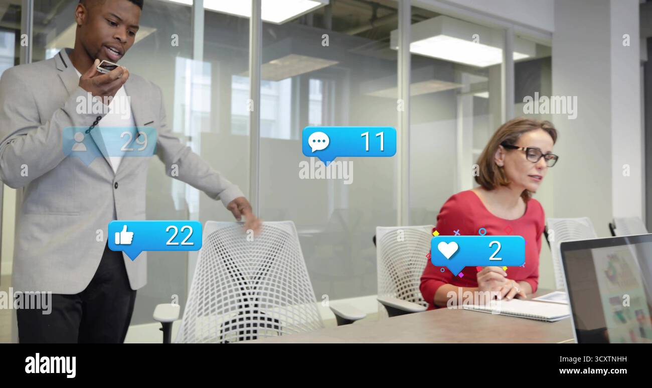 Presentazione di un uomo che indossa un abito che parla al microfono al tavolo da conferenza con icone fluttuanti dei social media Foto Stock