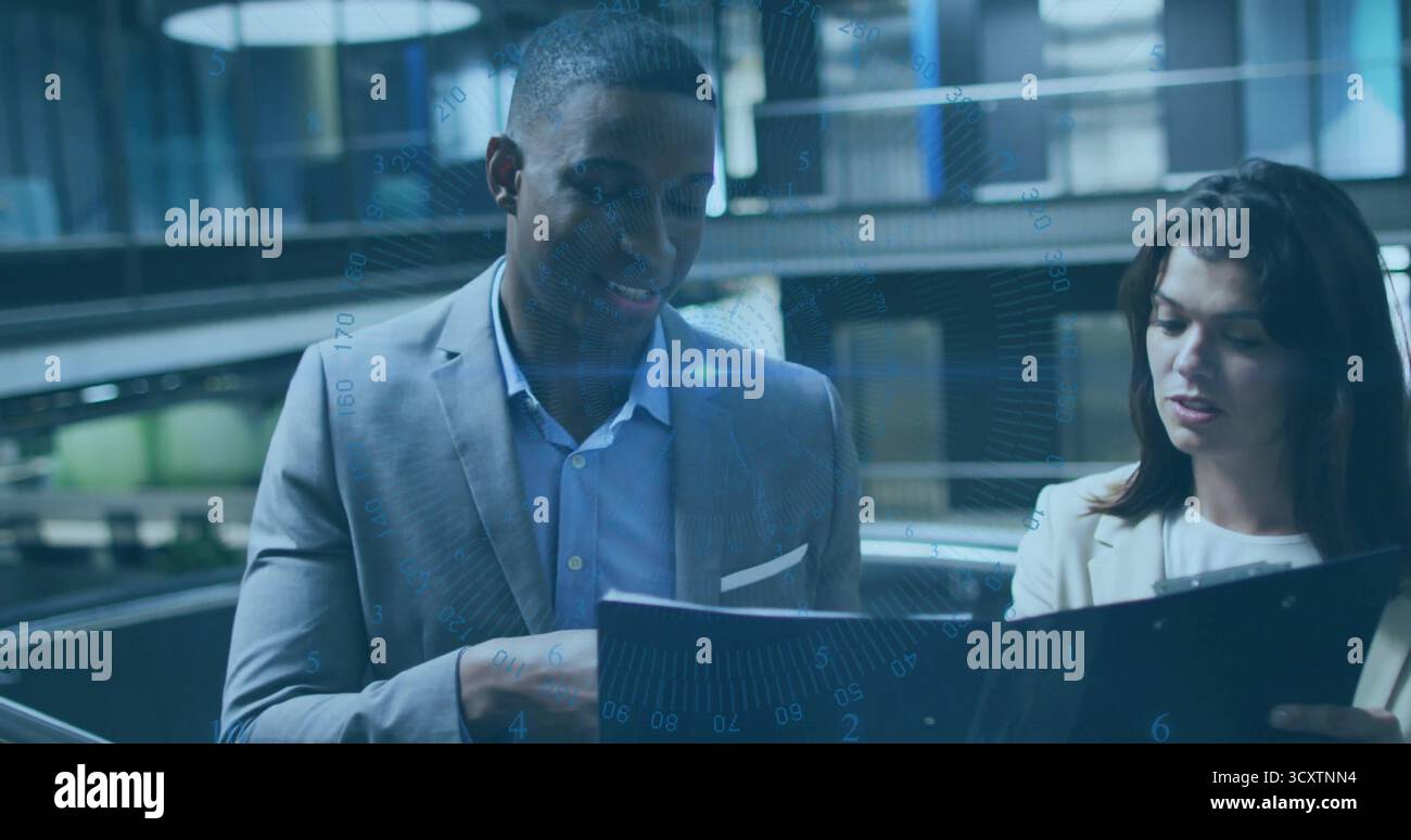 Revisione dei documenti colleghi appoggiati su un raccoglitore nero aperto nell'atrio dell'ufficio, sovrapposizione dei dati Foto Stock