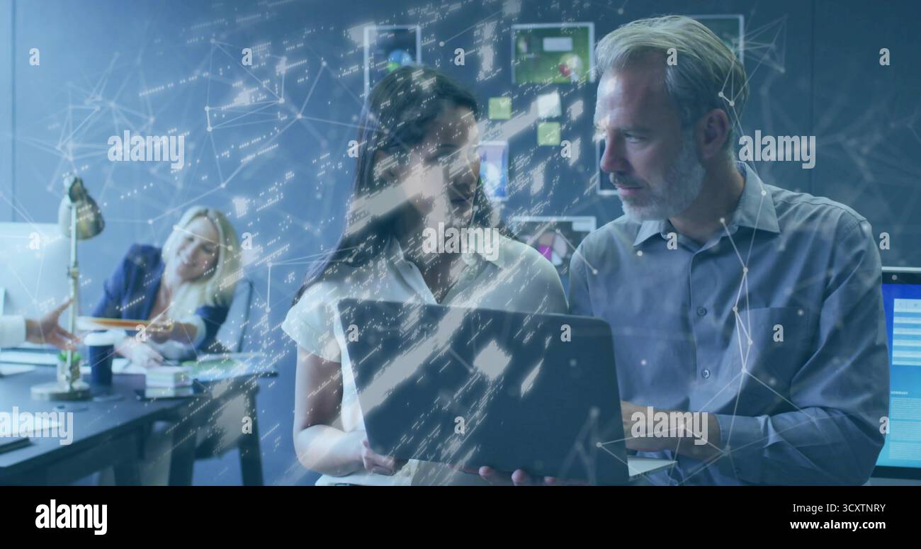 Esame dei dati dei laptop, due colleghi in un ufficio open space, con grafica di sovrapposizione della rete Foto Stock