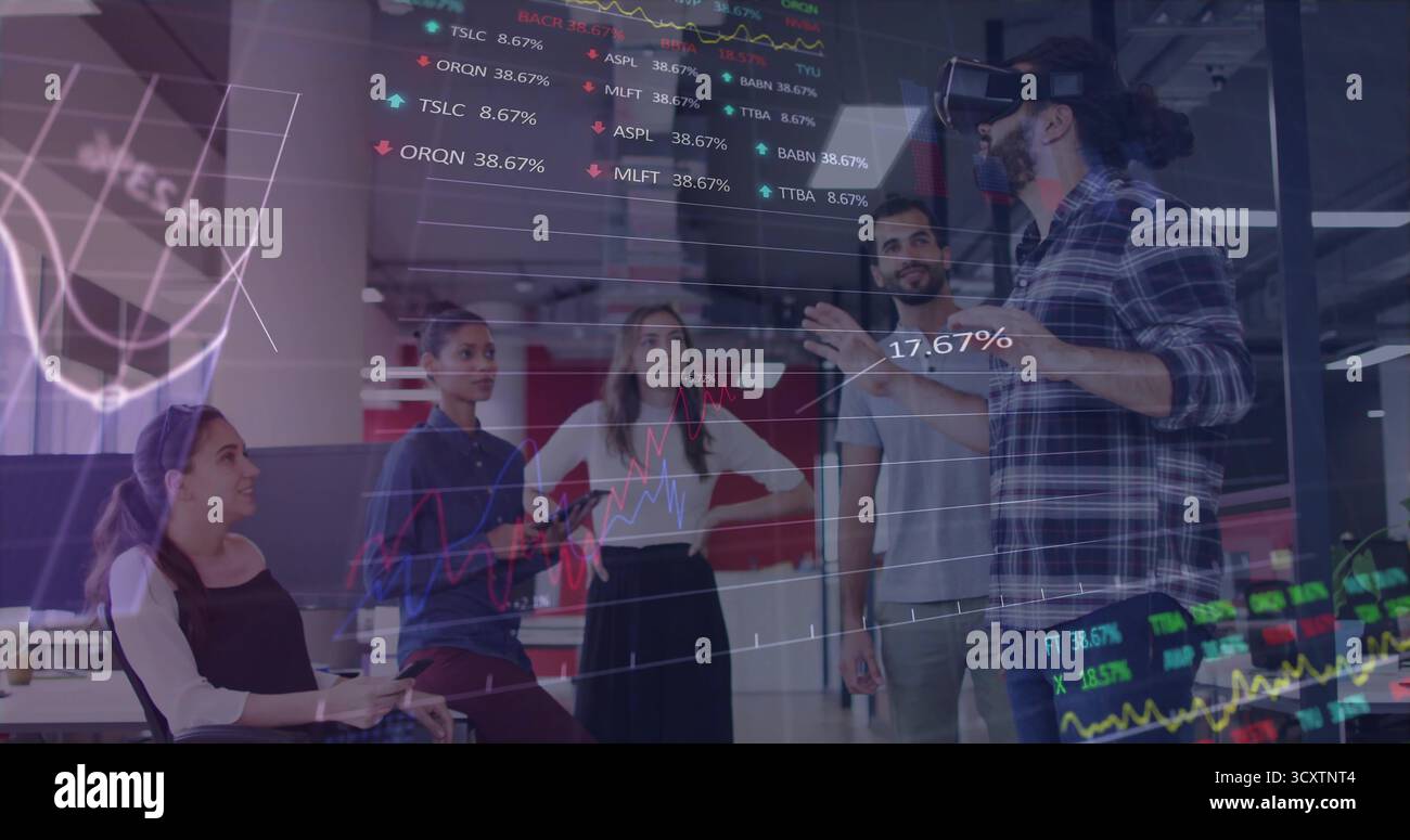 Riunire il team intorno al presentatore che indossa il visore VR in ufficio con sovrapposizioni finanziarie e spazio di copia Foto Stock