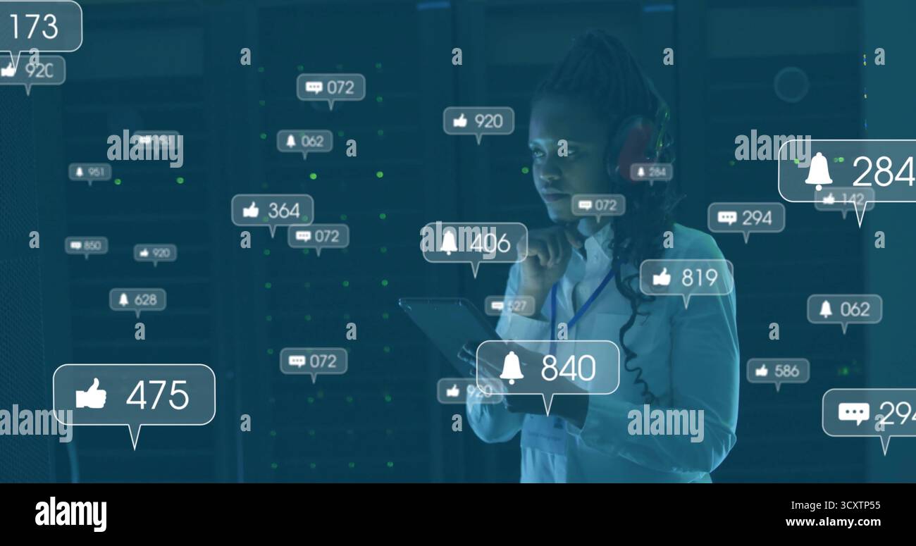 Monitoraggio dei rack server, professionisti IT con cuffia che tiene il tablet nel data center, con notifiche Foto Stock