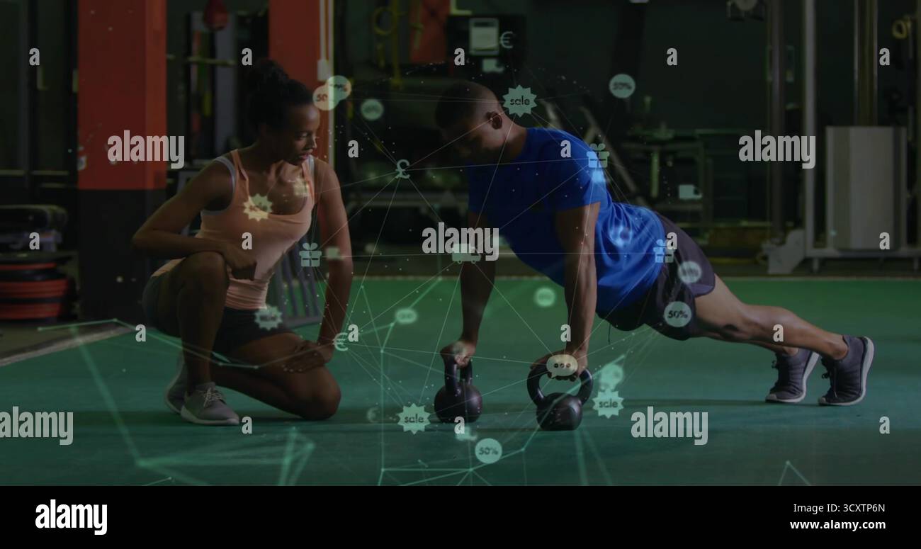 Istruttore che prepara un cliente maschio che fa push-up utilizzando i kettlebell in palestra, spazio per copiare Foto Stock