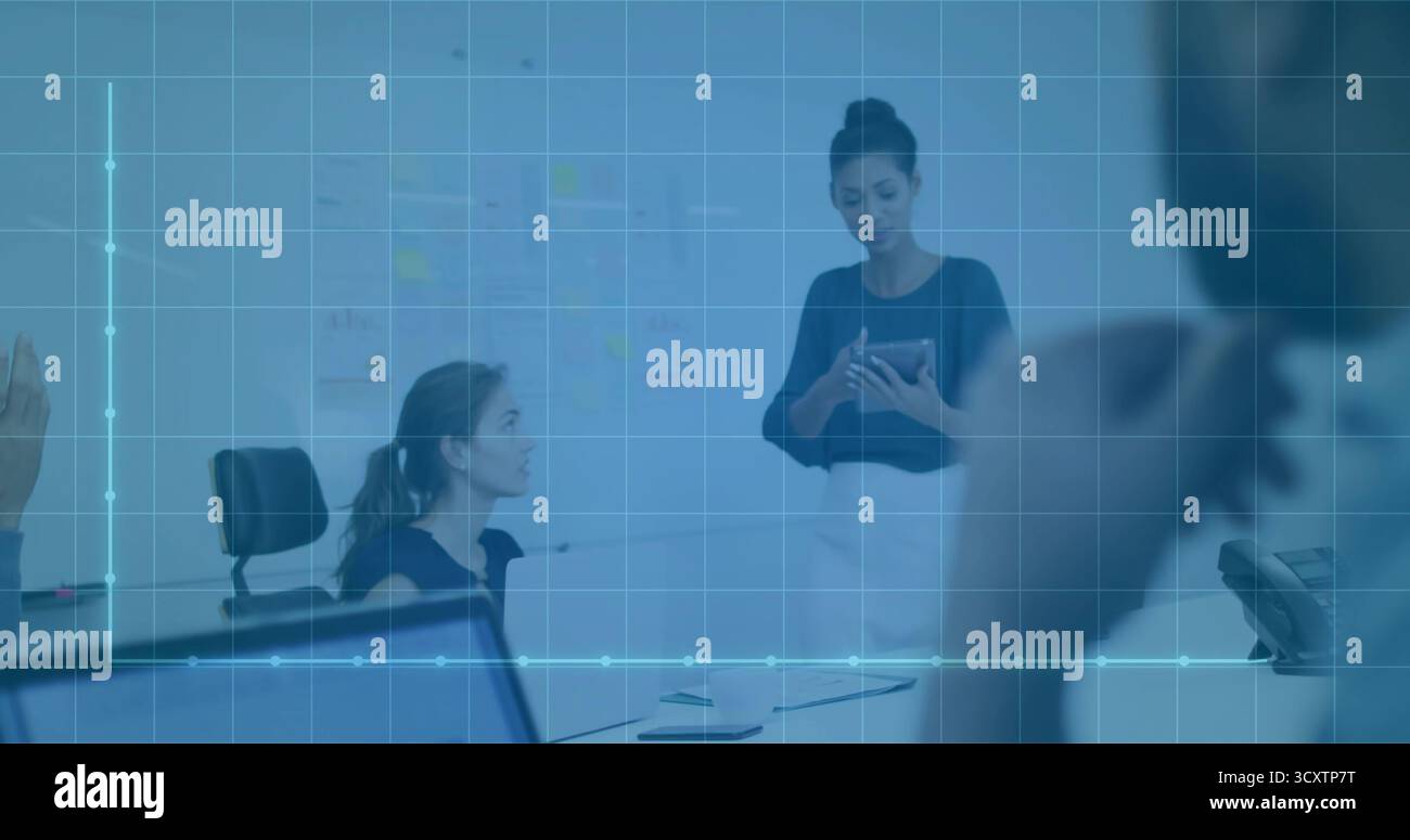 Donna leader in camicetta scura, gonna che presenta i dati su un tablet in sala conferenze, con lavagna bianca Foto Stock