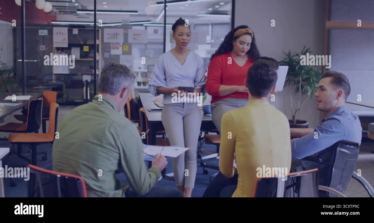 Discutere della collaborazione del team intorno al tavolo in sala conferenze, con sedia a rotelle, tablet, documenti Foto Stock