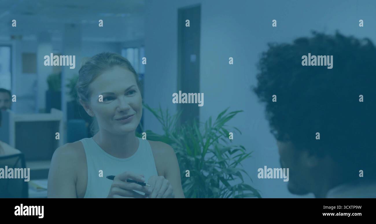 Donna professionale in gestazione con discussione di penna in un moderno ufficio open space, con monitor Foto Stock