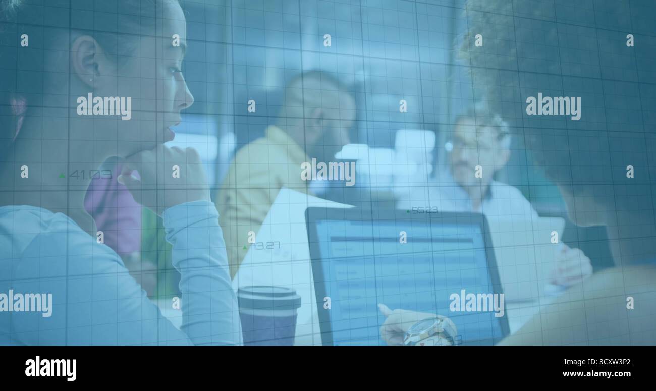 Discutere del team che esamina i documenti e indica lo schermo del notebook in sala riunioni, con tazze da caffè Foto Stock