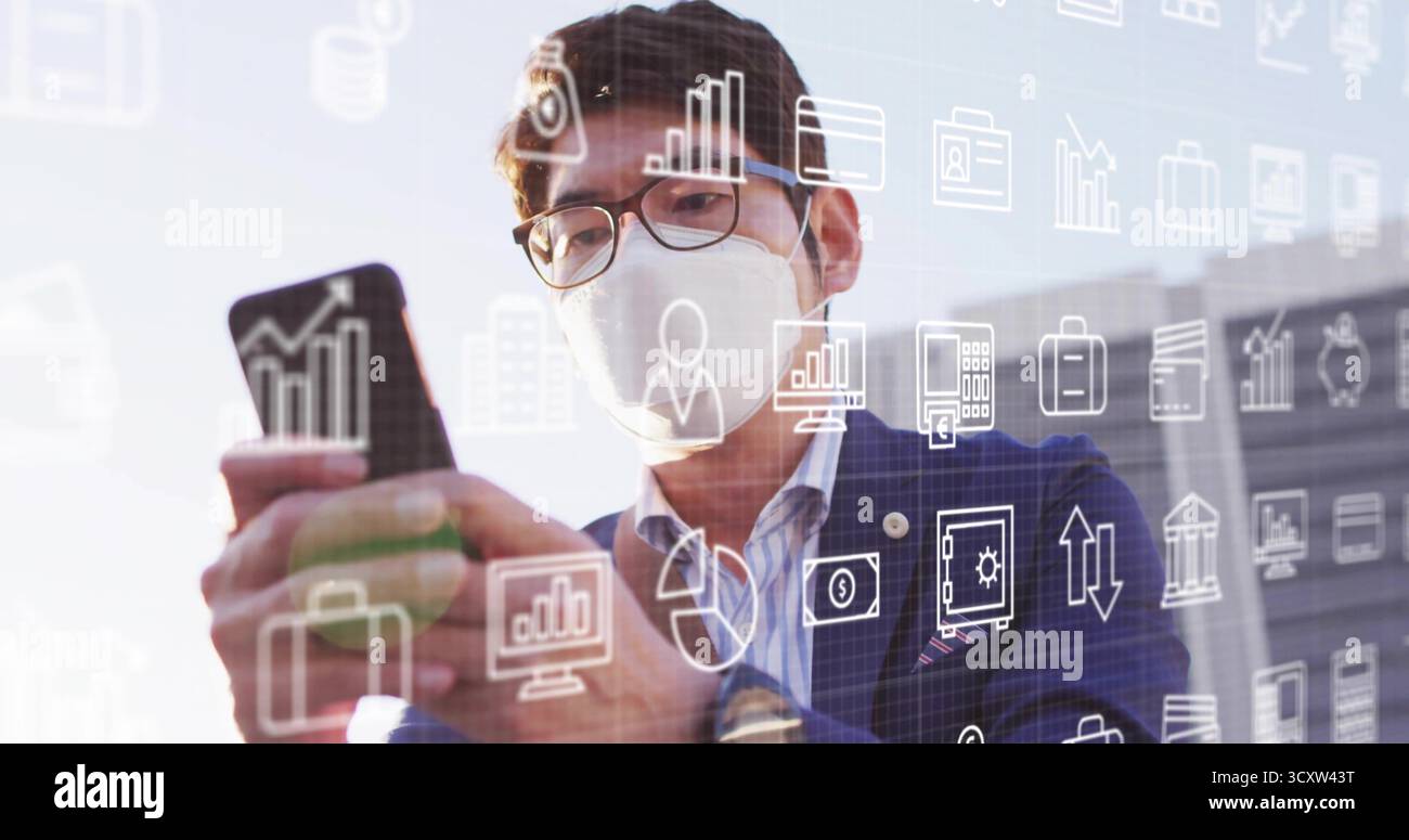 Controllare lo smartphone uomo d'affari asiatico che indossa una maschera per la facciata dell'ufficio, con icone di analisi fluttuanti Foto Stock