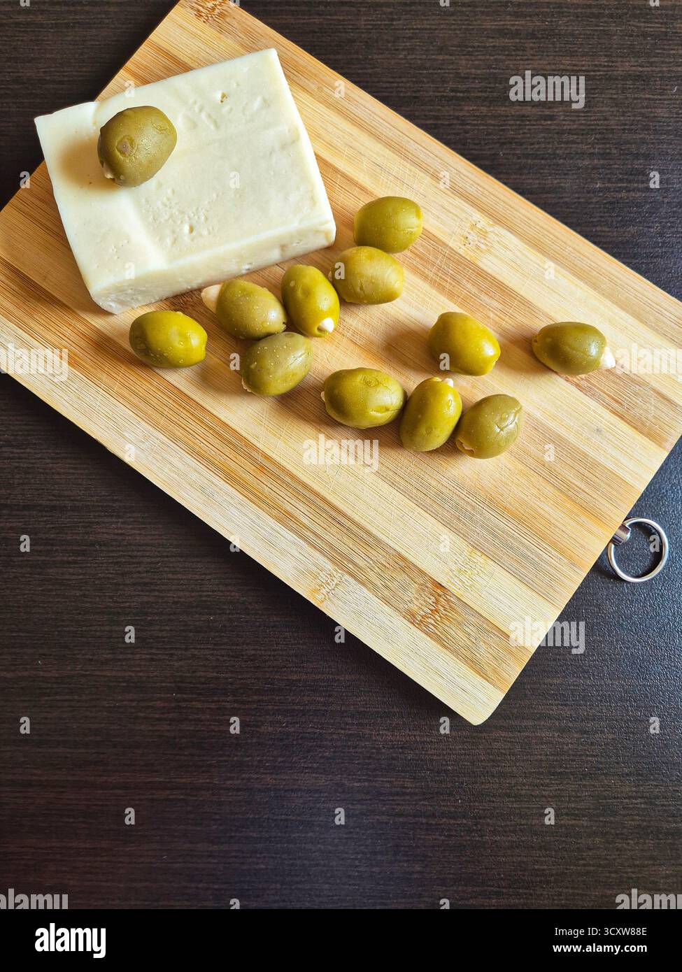 olive ricche e formaggio bianco salato (feta/brynza) su un tavolo di legno - Immagine stock catturata con smartphone