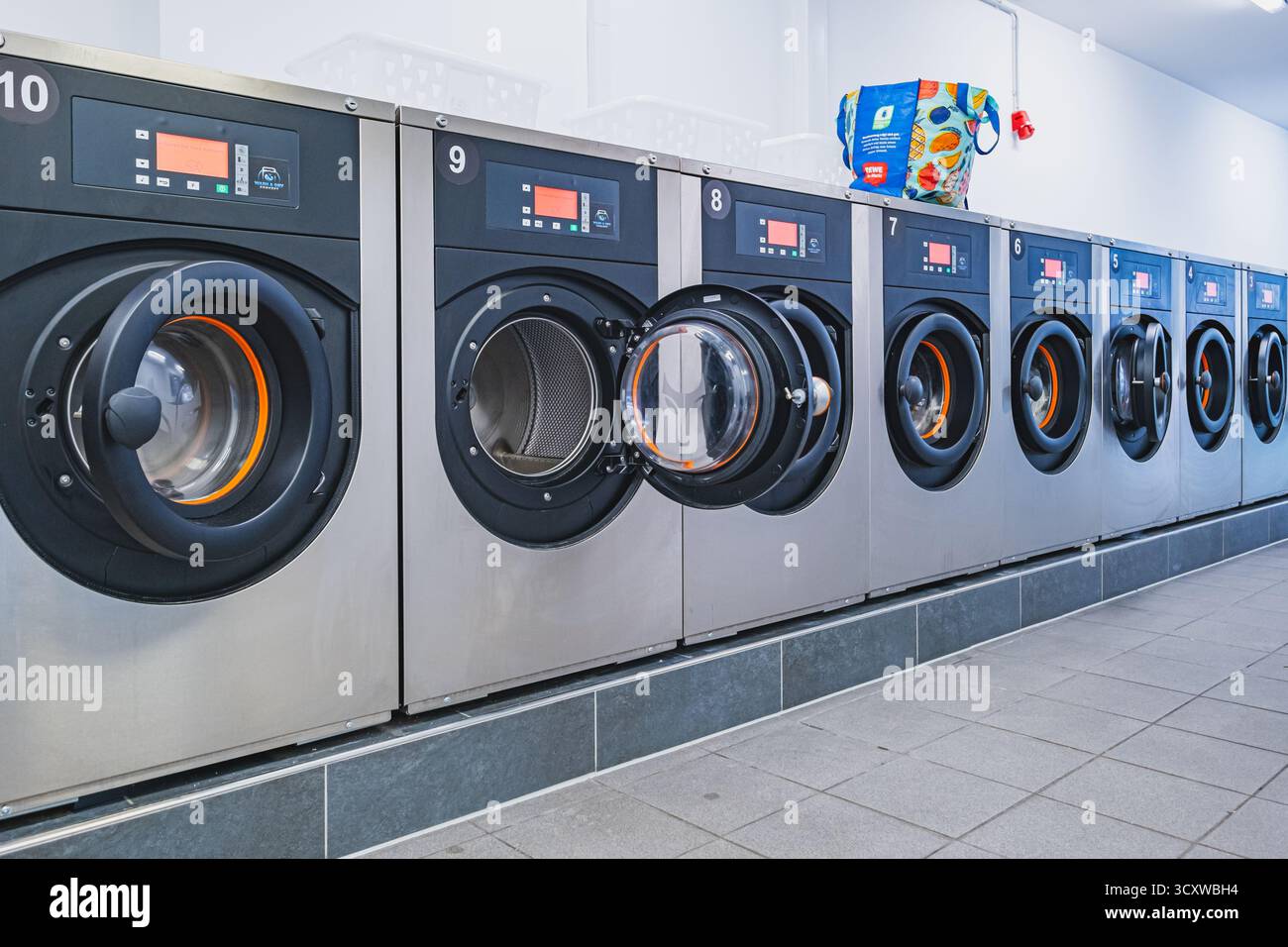 Fila di lavatrici in lavanderia self-service. Foto di alta qualità Foto Stock