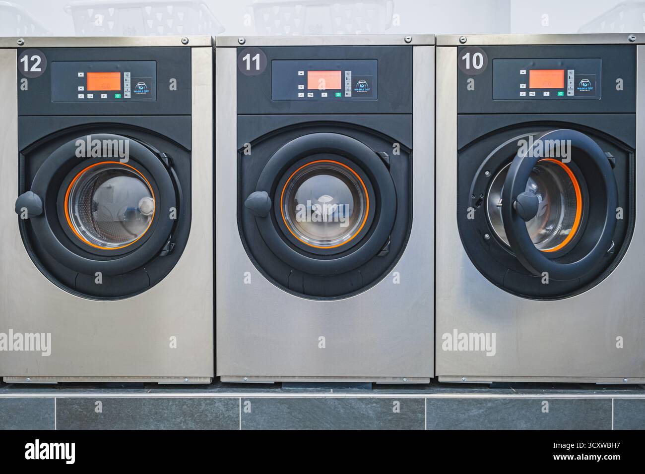 Fila di lavatrici in lavanderia self-service. Foto di alta qualità Foto Stock