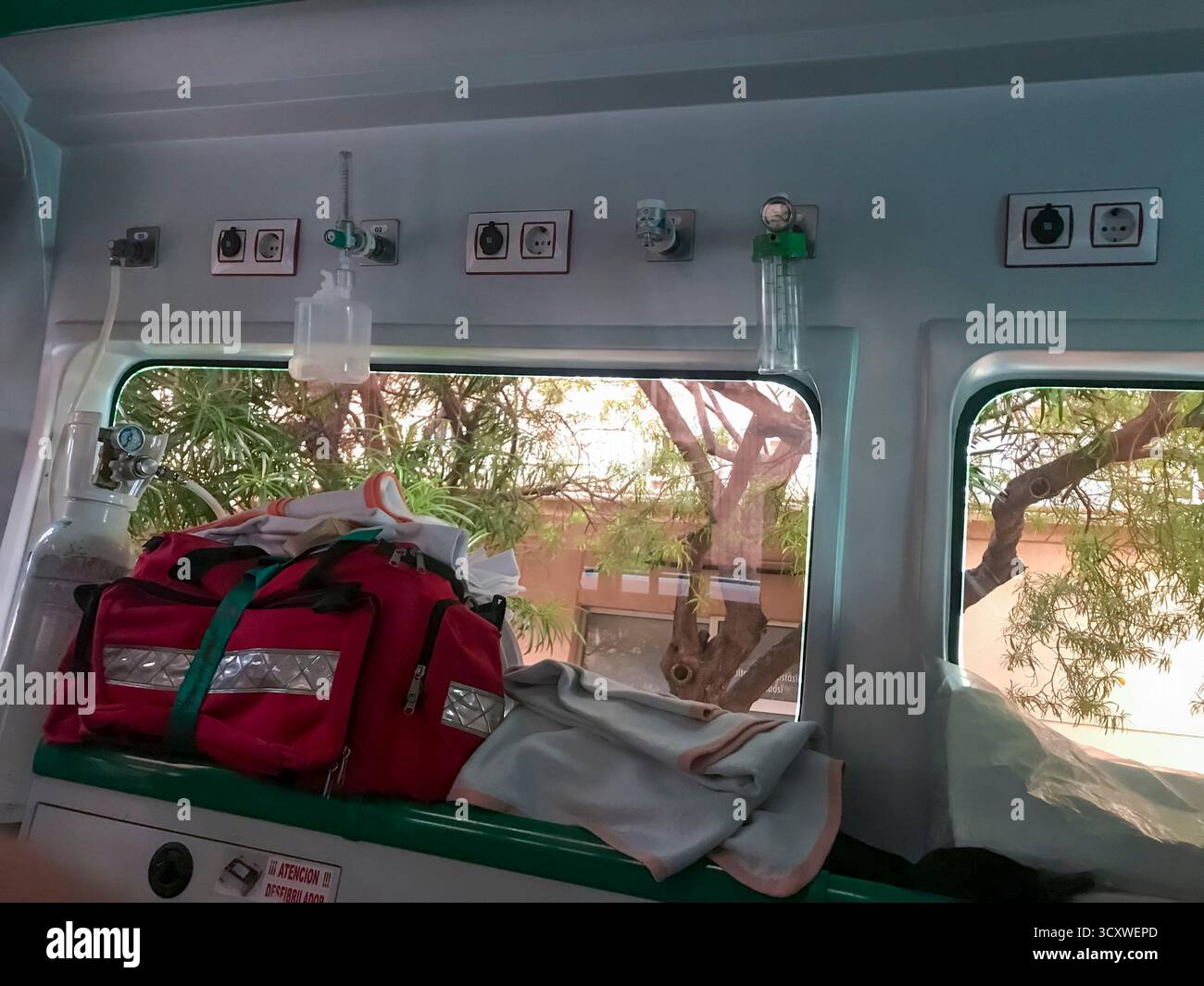 Una borsa rossa con una cinghia rossa si trova sul pavimento di un'ambulanza. Un altro sacchetto rosso con cinghia rossa è posizionato accanto ad esso. La scena sembra essere un farmaco Foto Stock