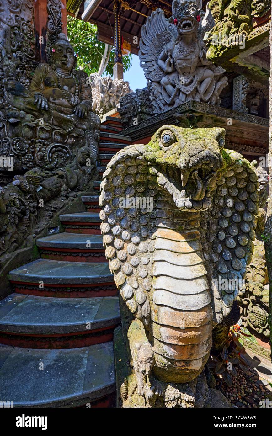 Statua in pietra di Naga, creatura semi-divina della mitologia indiana, intagliata in modo intricato nel tempio Puri Langon a Ubud, Gianyar, Bali, Indonesia. Foto Stock