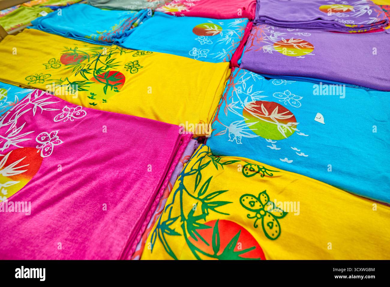 Ampia scelta di capi in tessuto di bambù piegati e esposti in un negozio di articoli da regalo. Kuta, Bali, Indonesia. Foto Stock