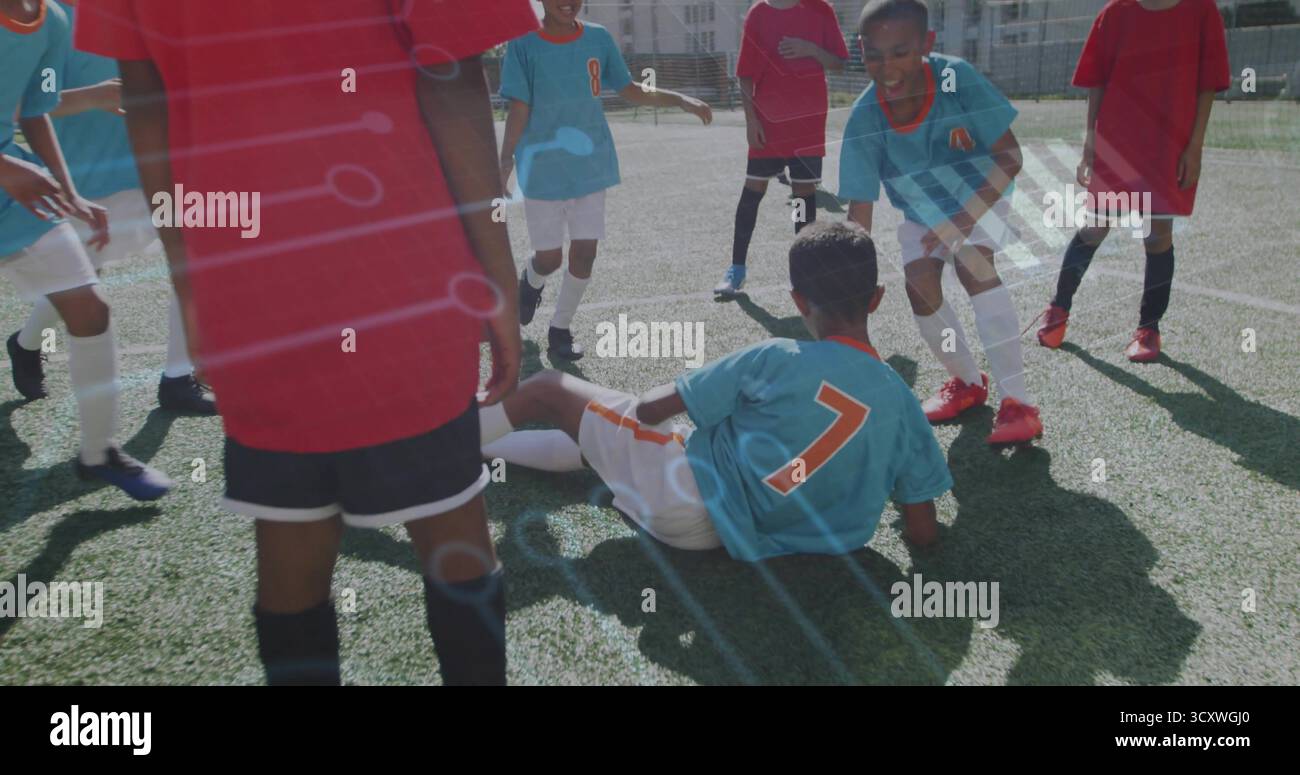 Ragazzo scorrevole in maglia azzurra che affronta la palla da calcio sul campo artificiale in erba, partita competitiva Foto Stock