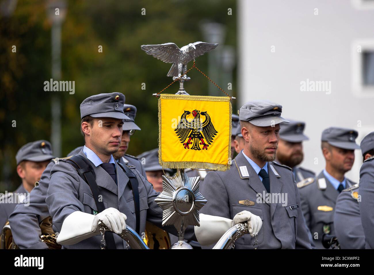 Indienststellungsappell der neuen Offizierschule der Luftwaffe, Roth, 15.10.2025 Angehörige des Gebirgsmusikkorps der Bundeswehr aus Garmisch-Partenkirchen in grauer Uniform mit Schirmmütze während einer Zeremonie auf dem Gelände der Offizierschule der Luftwaffe in Roth, Bayern. Im Vordergrund eine Paradeschwenkfahne mit Bundesadler und silberner Fahnenspitze in forma eines Adlers. Die Soldaten stehen in Reih und Glied, der Hintergrund ist unscharf. Roth otto-Lilienthal-Kaserne Bayern Deutschland *** messa in servizio della nuova Air Force Officer School, Roth, 15 10 2025 membri della Bu Foto Stock