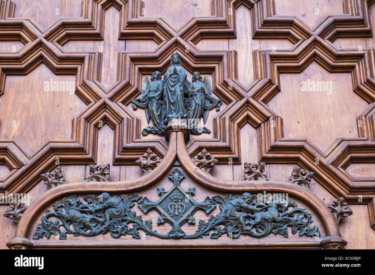 Porta in legno con intagli ornati e rilievi religiosi Foto Stock