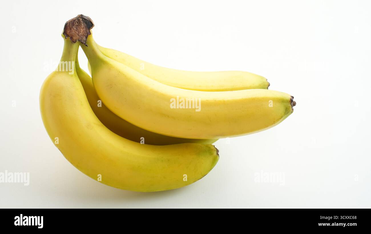 Un mucchio di banane gialle da vicino, isolate su sfondo bianco Foto Stock