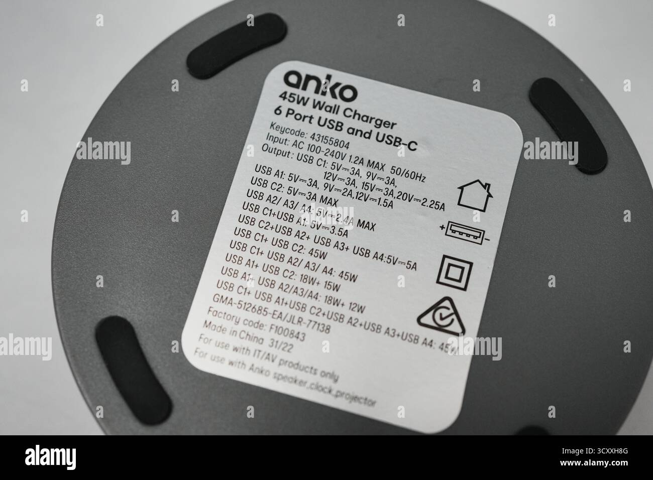 Londra, Regno Unito – 2025.10.16 – primo piano di un hub di ricarica USB circolare nero dotato di più porte USB-A e USB-C, tra cui QC 3,0 fast ch Foto Stock