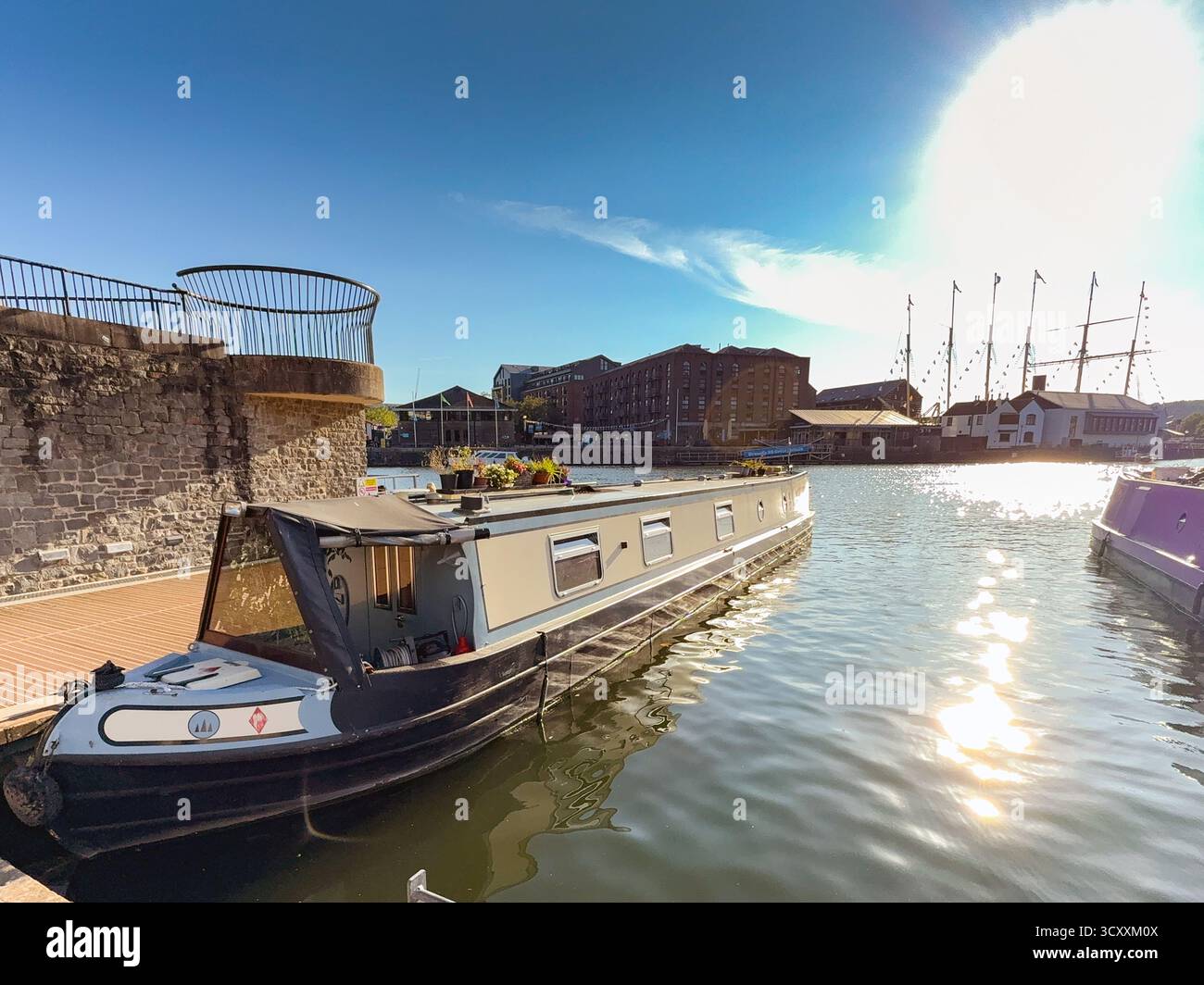 Bristol, Avon, Inghilterra, Regno Unito - 25 aprile 2025: Barca stretta ormeggiata al crepuscolo nella zona rigenerata dei moli della città - Immagine stock catturata con smartphone