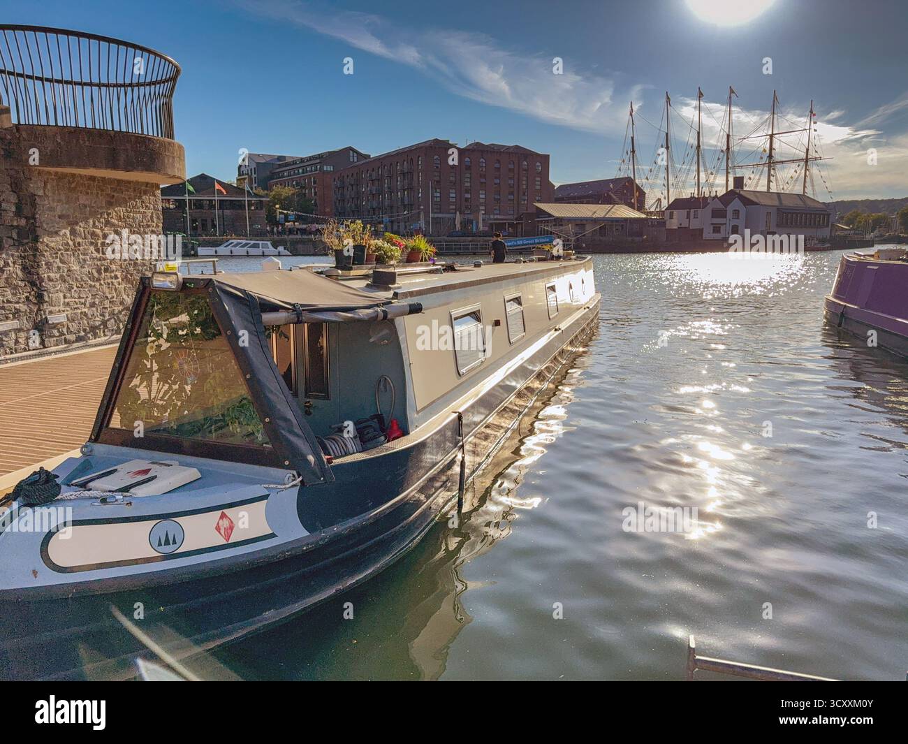 Bristol, Avon, Inghilterra, Regno Unito - 25 aprile 2025: Barca stretta ormeggiata al crepuscolo nella zona rigenerata dei moli della città - Immagine stock catturata con smartphone